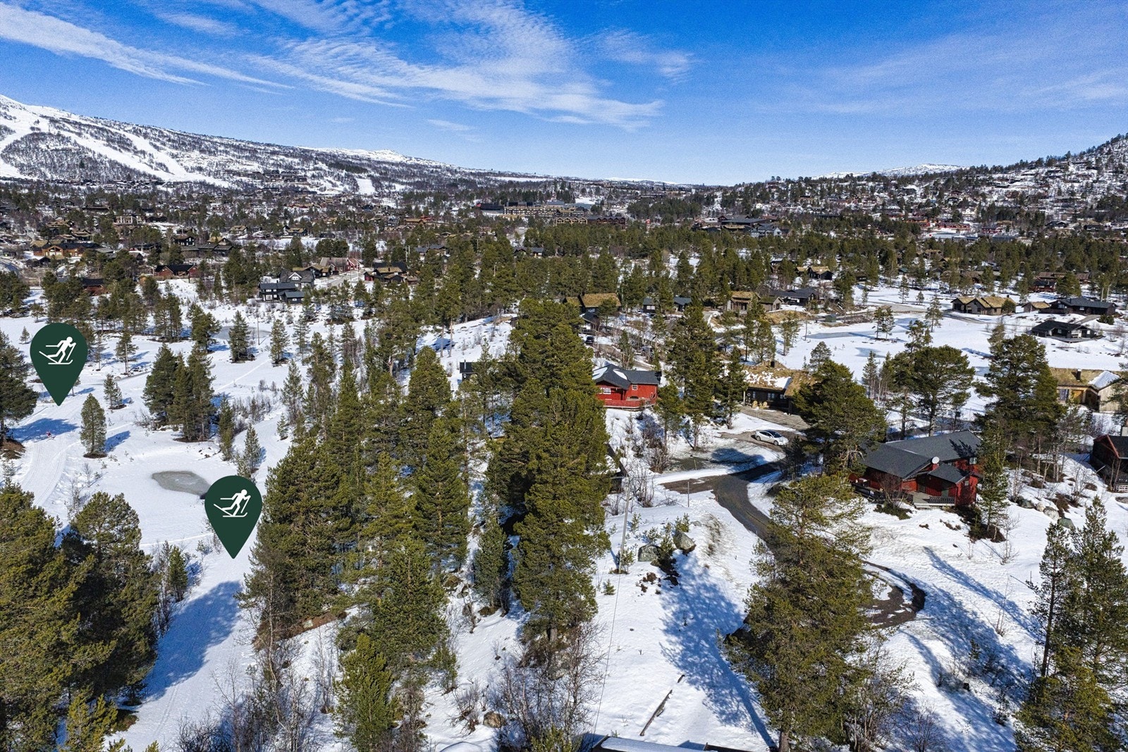 Oppkjørte langrennsløyper rett ved tomten. Skisenteret i bakgrunnen til venstre. Galleribilde