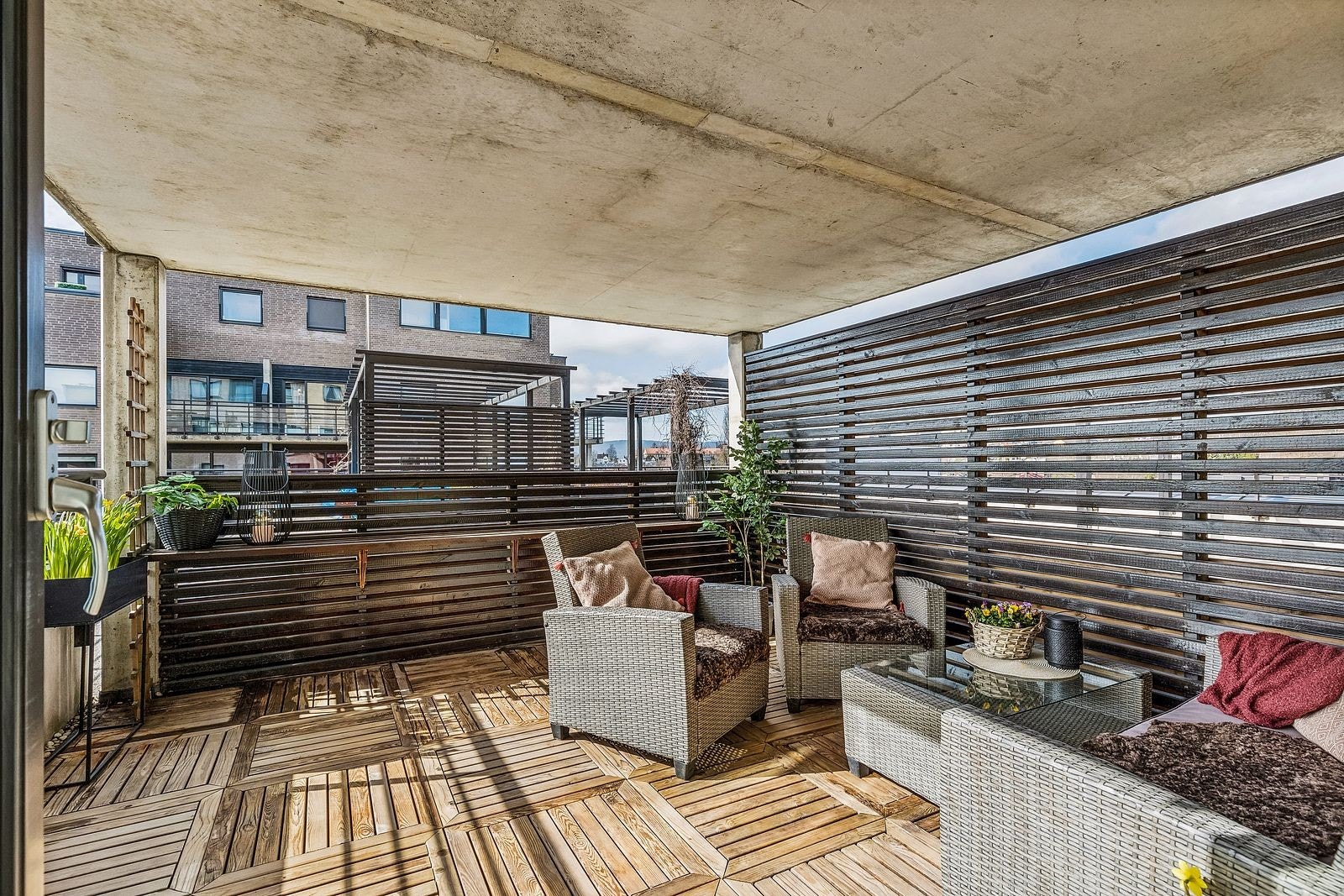 Terrasse med utemøbler. Leiligheten er i samme etasje som byggets felles takterrasse. Galleribilde