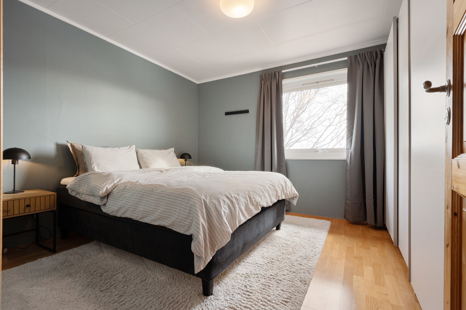 Soverom 1 har vegger i en delikat fargetone og rikelig plass til både dobbeltseng og tilhørende nattbord Galleribilde