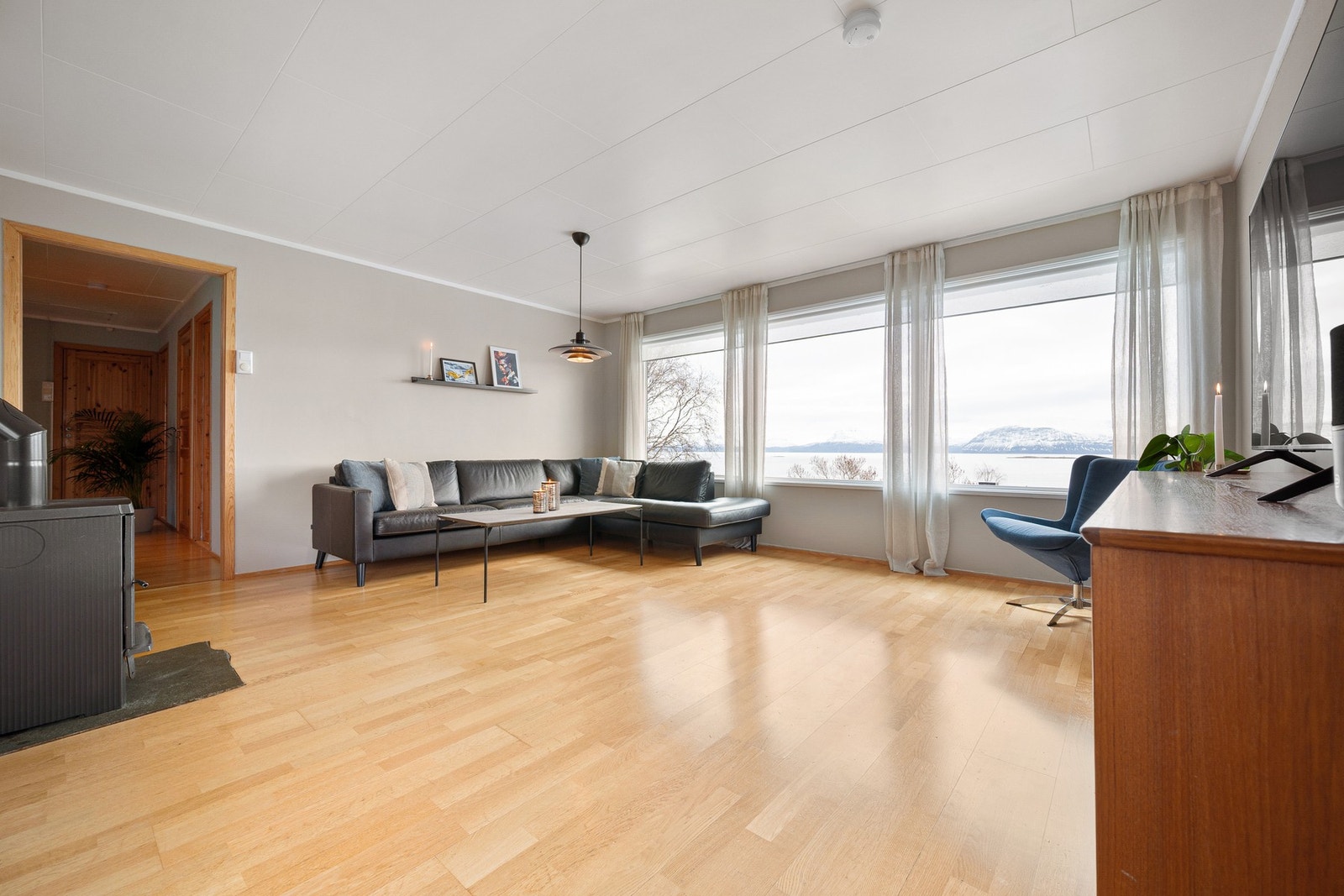 Lys og luftig stue med vindusflater langs hele veggen bidrar med gode lysforhold Galleribilde