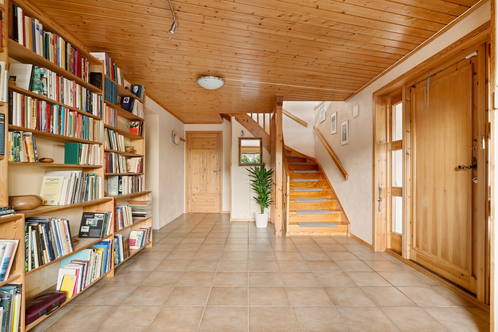 Romslig og lys entré med fliser og plass til å ønske gjester velkommen Galleribilde