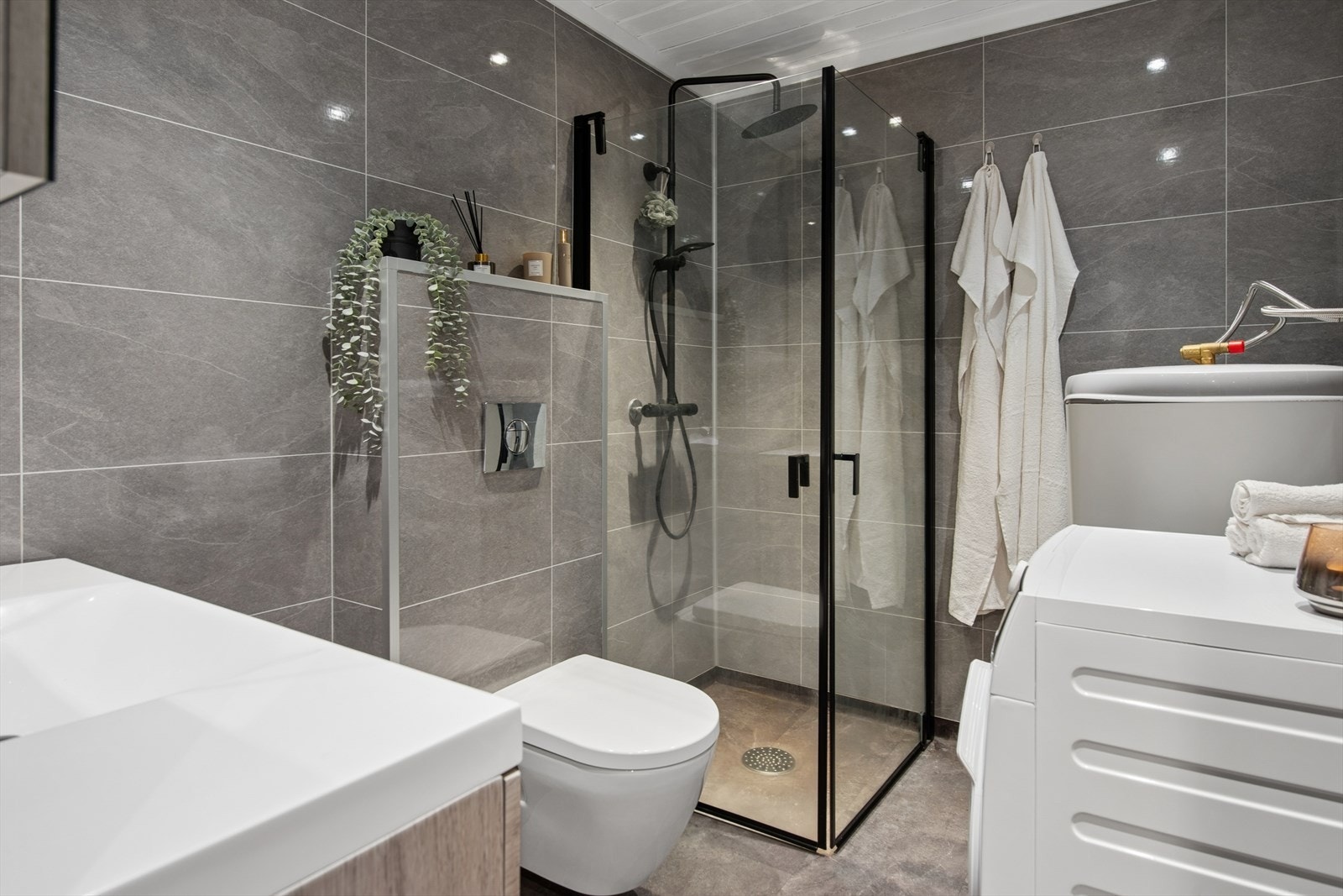 Rommet har veggmontert WC og dusjhjørne med innfellbare vegger for optimal plassutnyttelse. Galleribilde
