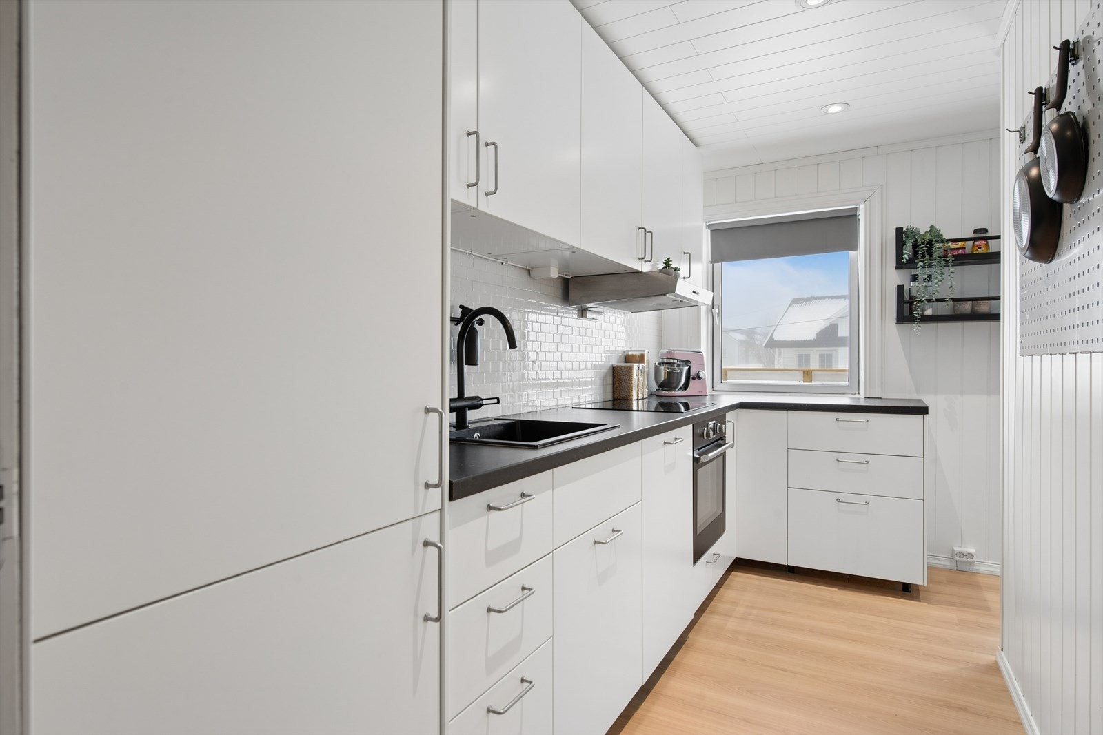 Moderne kjøkken med glatte fronter og fullt integrerte hvitevarer. Galleribilde