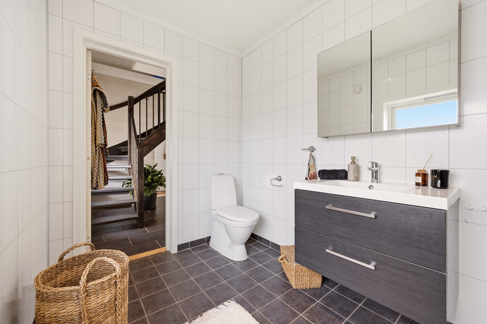 Badet er utstyrt med heldekkende servant med underskap, speilskap, toalett og dusjkabinett Galleribilde