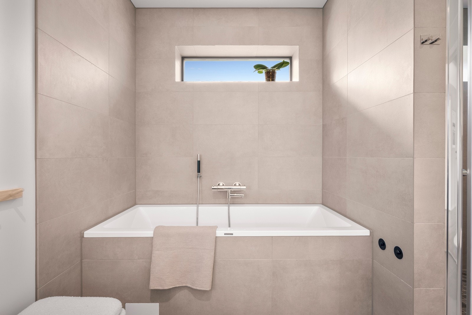 Badet er utstyrt med både badekar og en romslig dusjløsning. Galleribilde