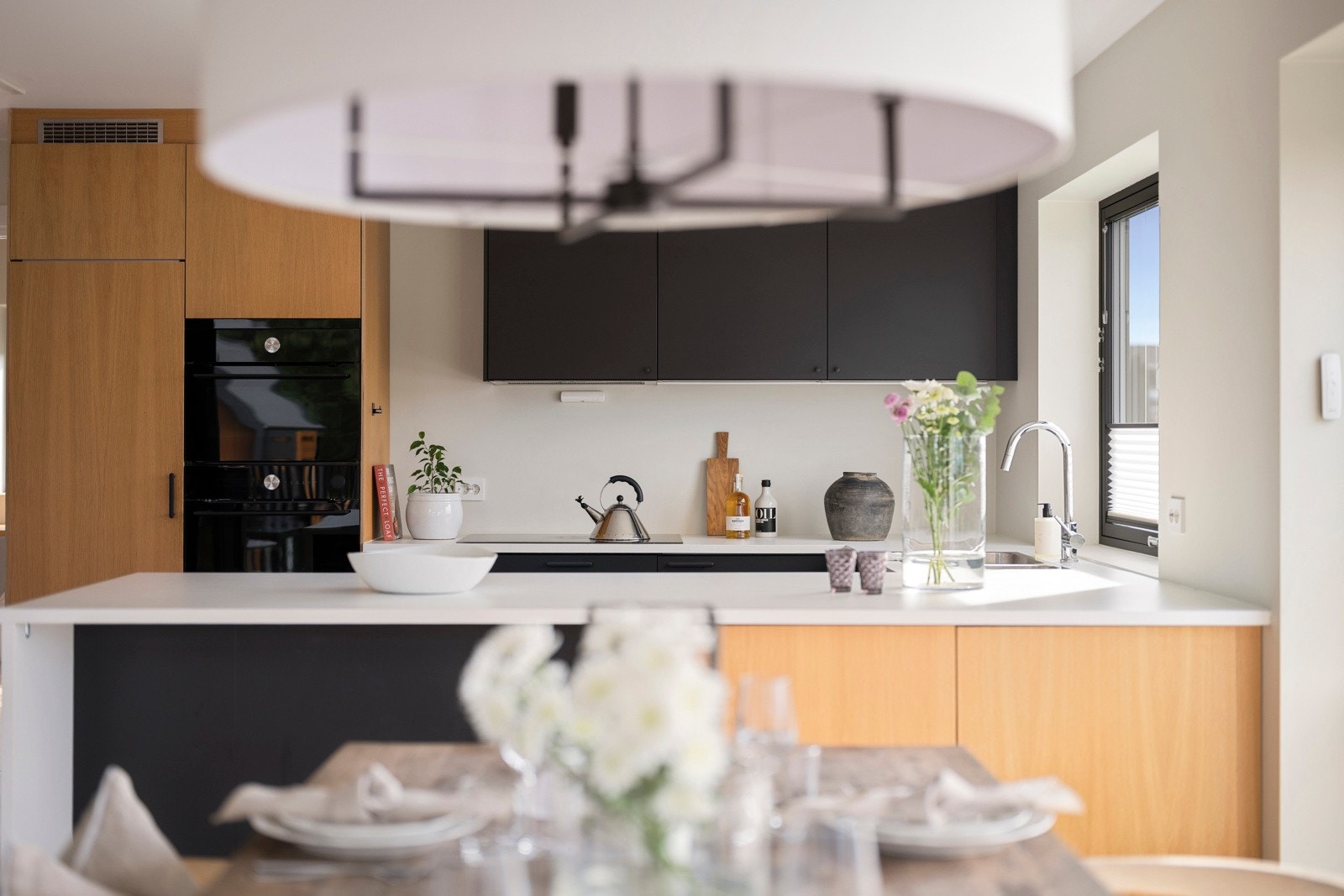 Kjøkkenet er moderne og stilrent med rene linjer, slette fronter og en gjennomført materialpalett som gir et tidløst uttrykk. Galleribilde