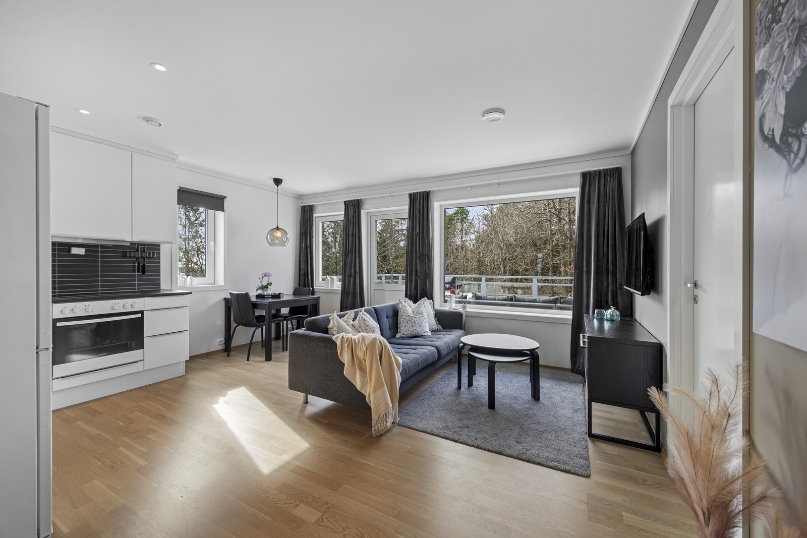 Lys og fin stue/kjøkkenløsning. Plass til spisesbord og utgang til veranda. Downlights i tak. Galleribilde