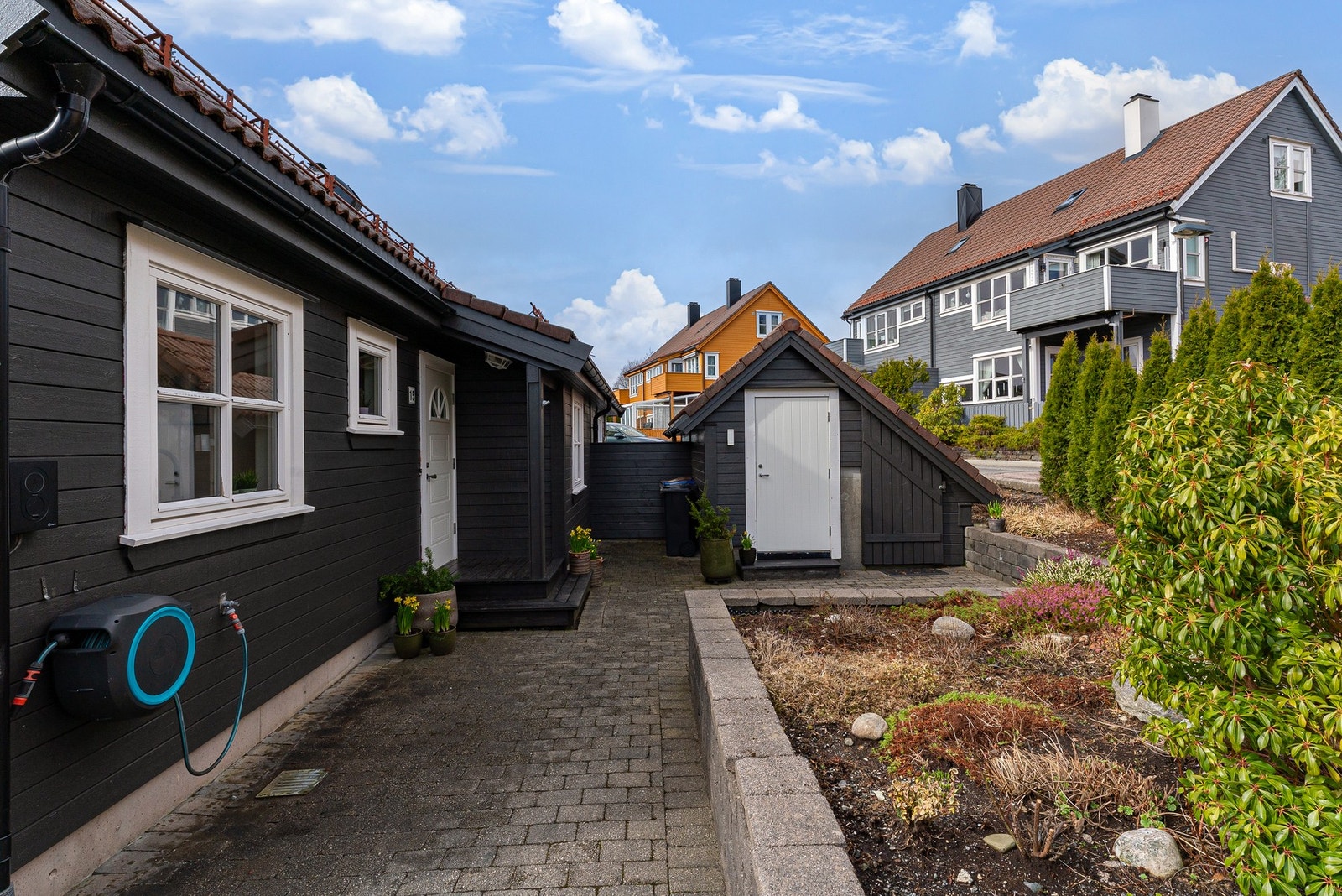 Fint opparbeidet inngangsparti med murer, bed, bod og beleggningsstein. Galleribilde