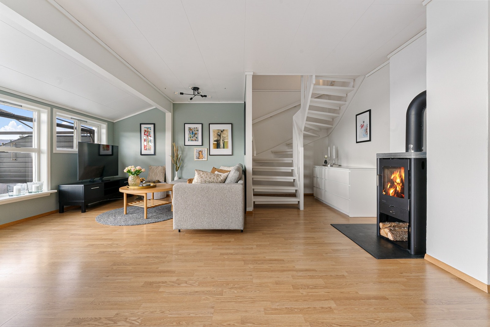 Stue med varmekabler i gulv og vedovn Galleribilde