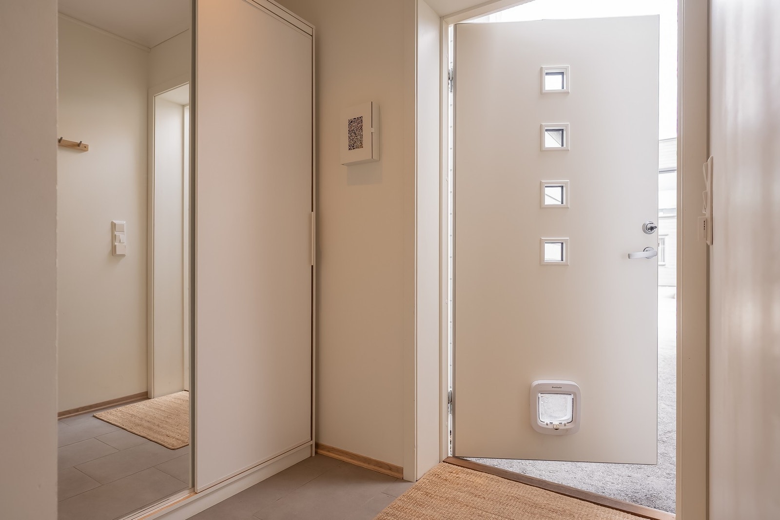 Lys og tiltalende entré med flislagt gulv med varmekabler samt godt med lagring i skyvedørsgarderobe Galleribilde