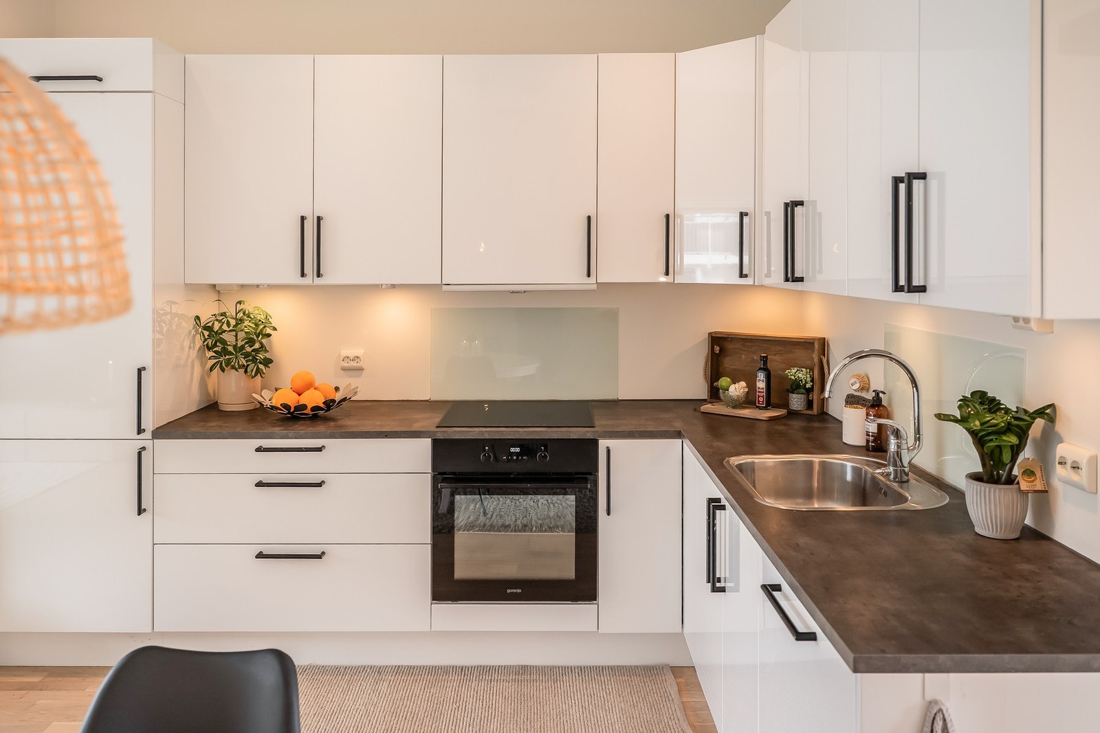 Pent kjøkken med integrerte hvitevarer og godt med skap- og benkeplass Galleribilde