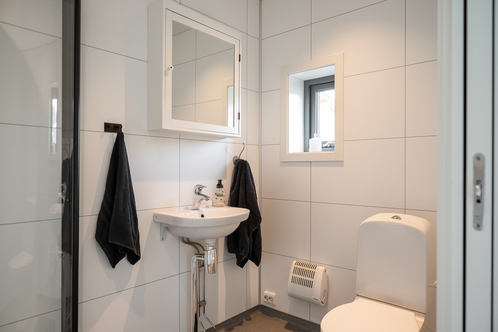 Dette badet er innredet med dusjhjørne, toalett og servant Galleribilde