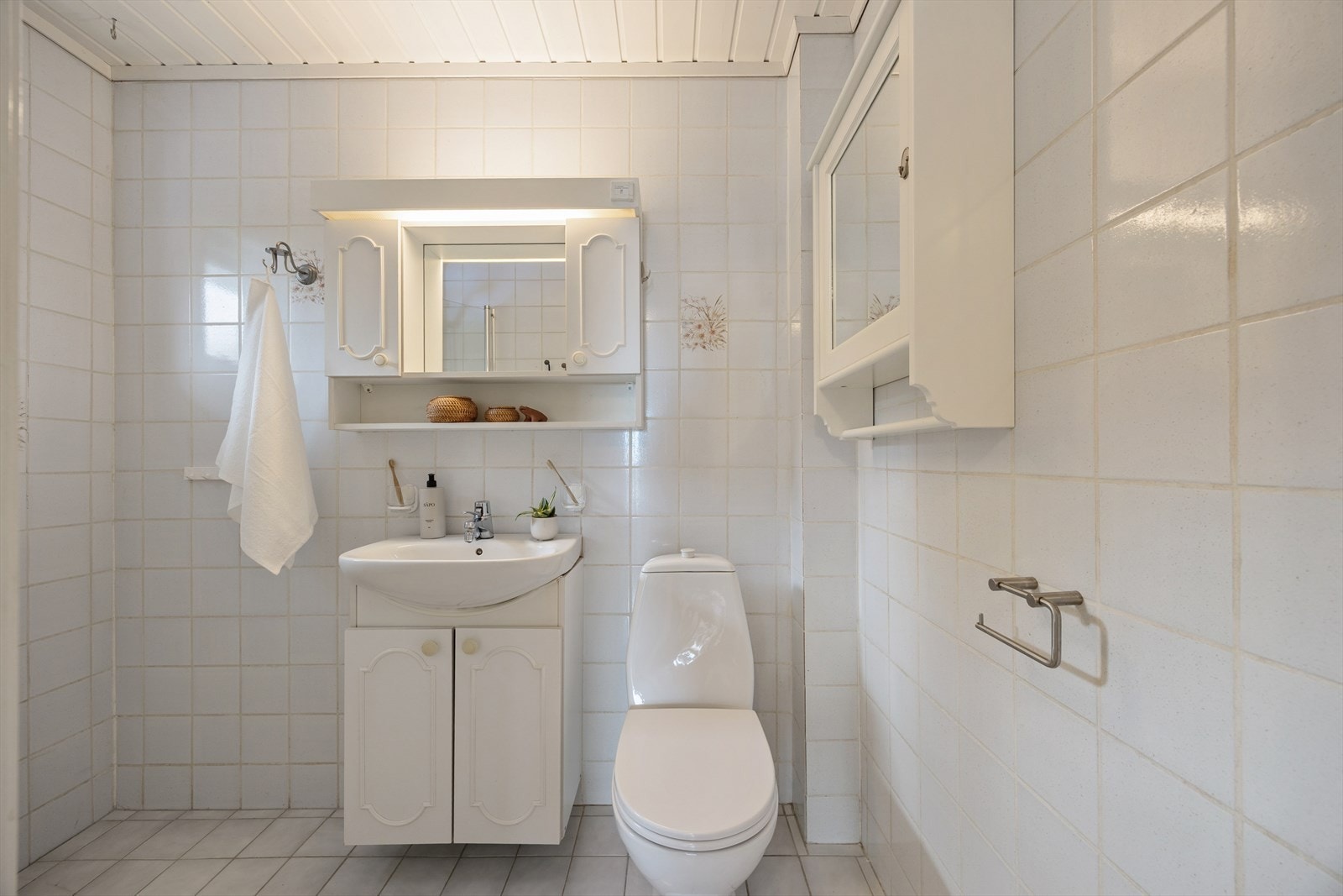 Flislagt bad med servant, toalett og dusjløsning. Galleribilde