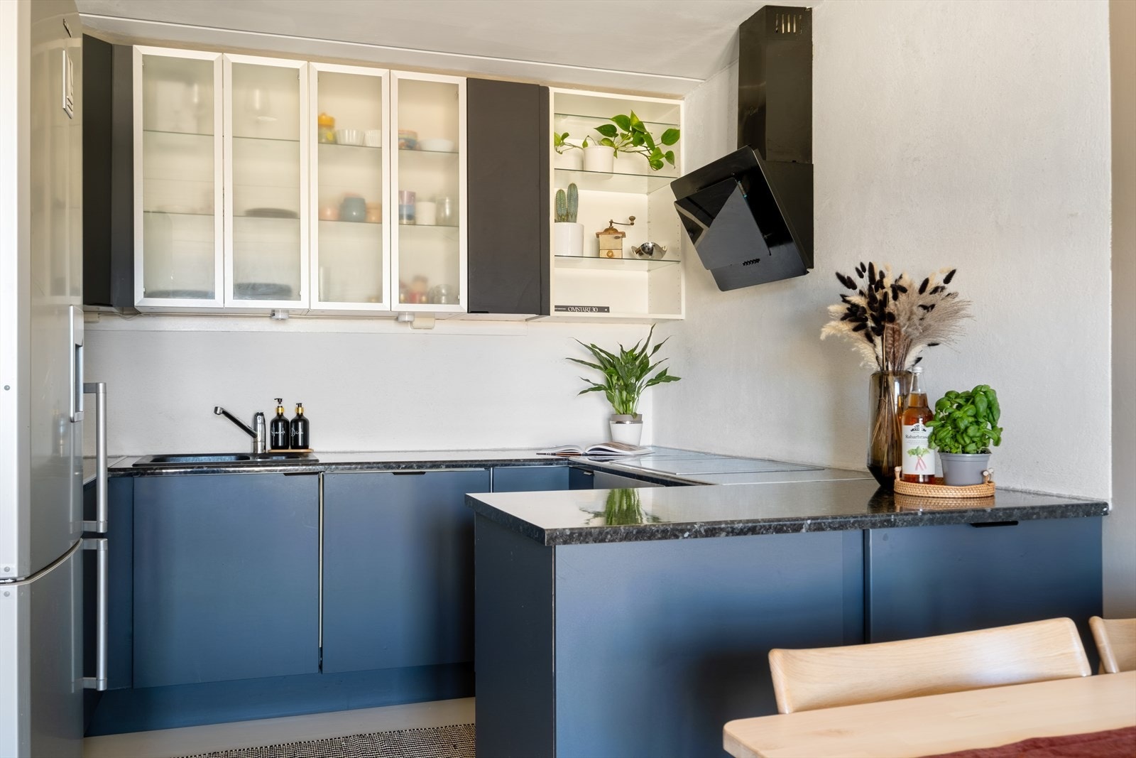 Kjøkkeninnredningen med glatte fronter og laminat benkeplate. Kjøkkenventilator fra 2024. Galleribilde