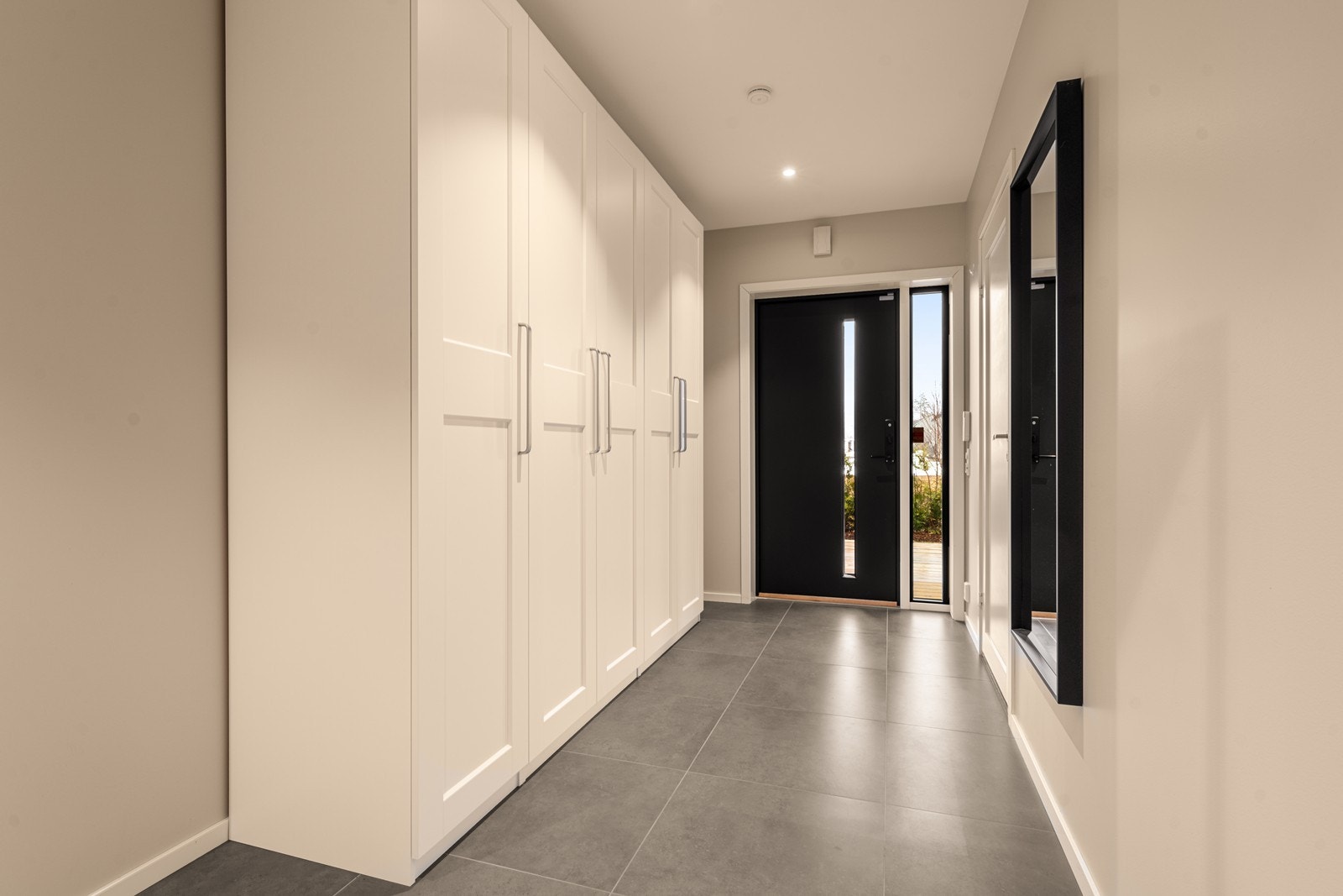 Entré/gang med fliser og varme i gulv samt stort garderobeskap. Det er i tillegg egen, direkte inngang fra dobbeltgarasjen Galleribilde