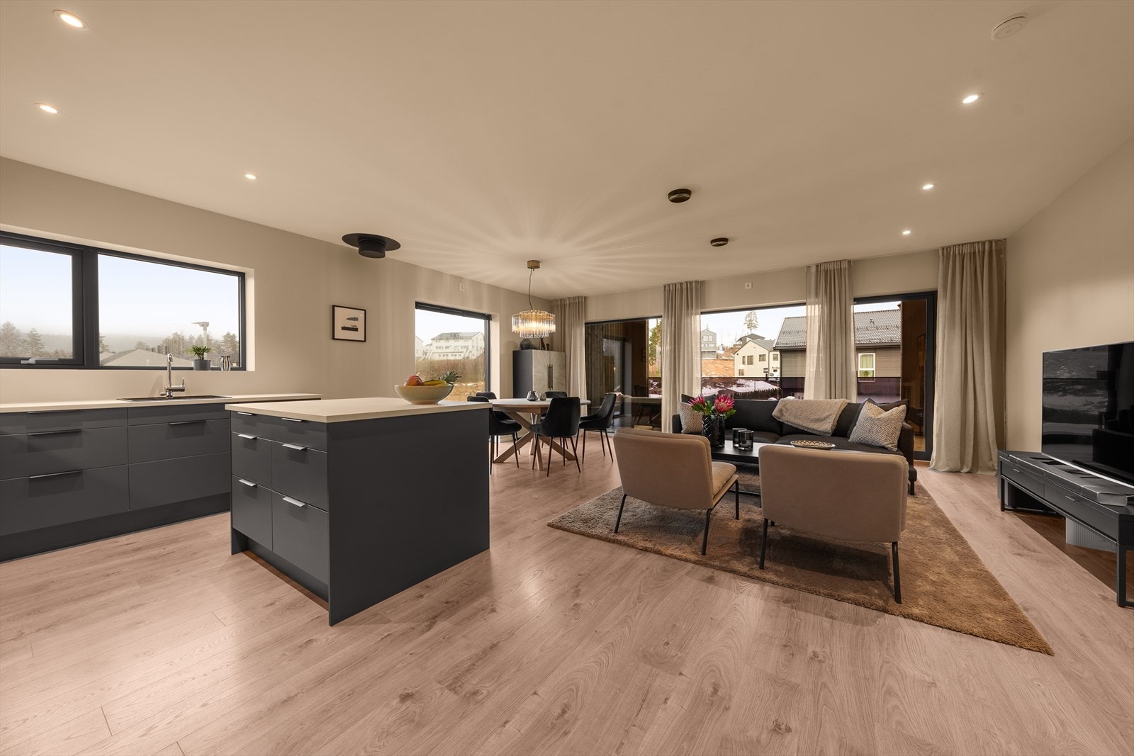 Stor stue med moderne og fine fargevalg. Downlights i himling og store vindusflater mot syd (langsiden) gir gode naturlige lysforhold Galleribilde