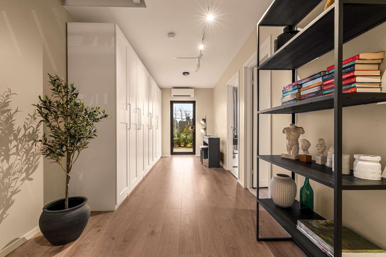 Tv-stue i 1.etasje innredet med løse garderobeskap og utgang til terrassen Galleribilde