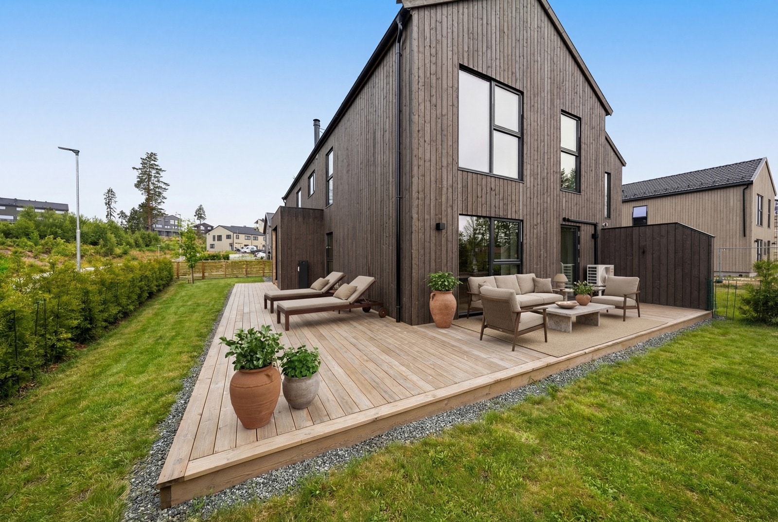 Store uteområder og stor terrasse. Hagen er pent skjermet inn med Thuja og gjerde. Gode solforhold i sydvendt del av hagen. Bildet er digitalt møblert og redigert og avvik kan dermed forekomme Galleribilde