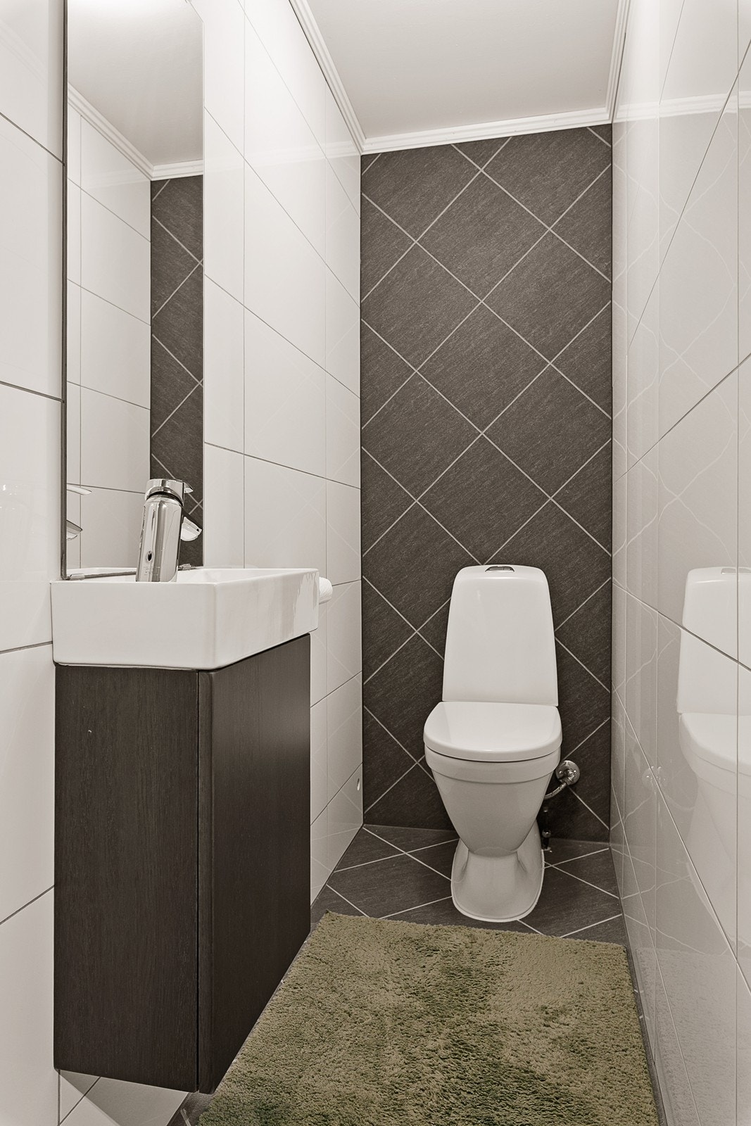 Toalettrom med wc og håndvask med skap og speil. Galleribilde