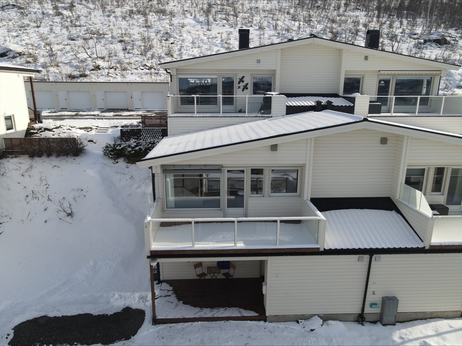 Parkering like utenfor inngangsdøren, elbilader montert på vegg. Galleribilde