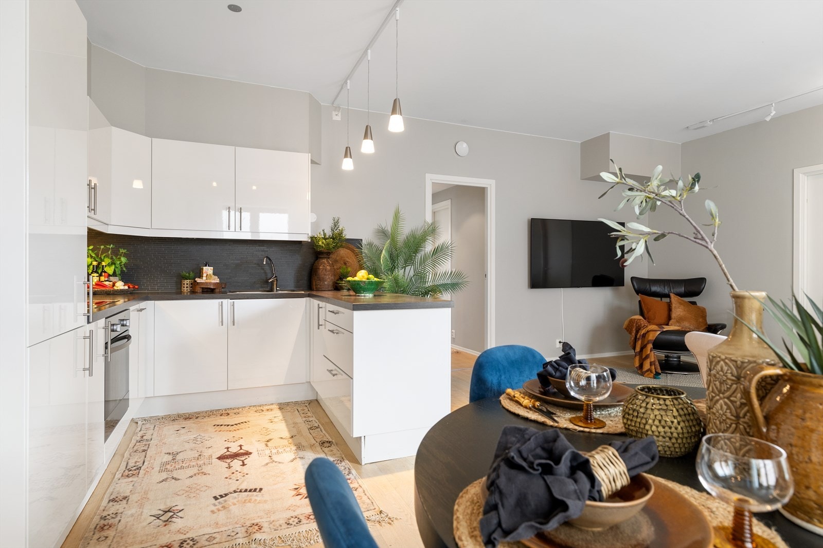 Kjøkkenet er innredet med slette hvite fronter og laminat benkeplate. Galleribilde