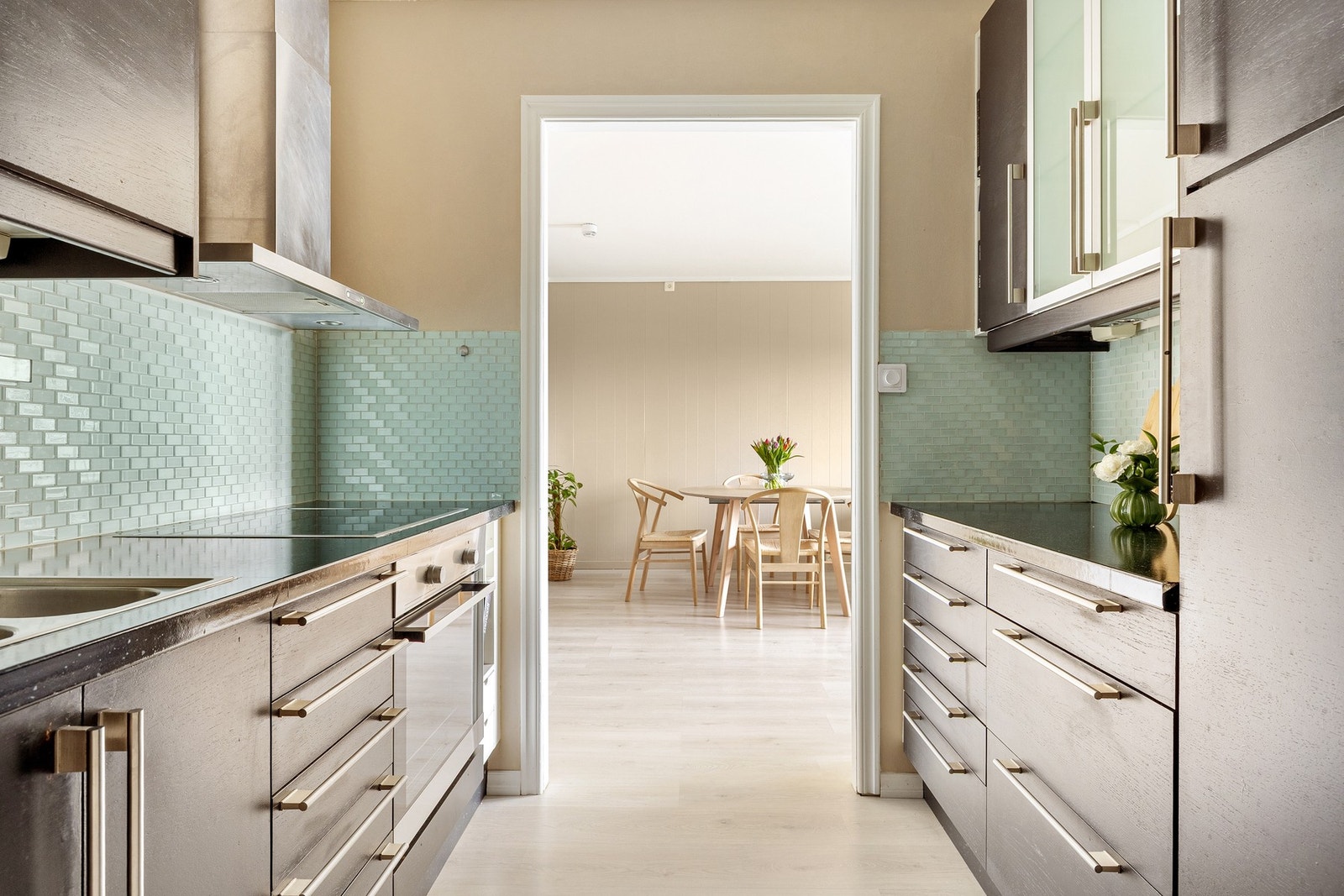 IKEA kjøkken med slette fronter, foliert benkeplate og fliser på vegg over benkeplate. Galleribilde