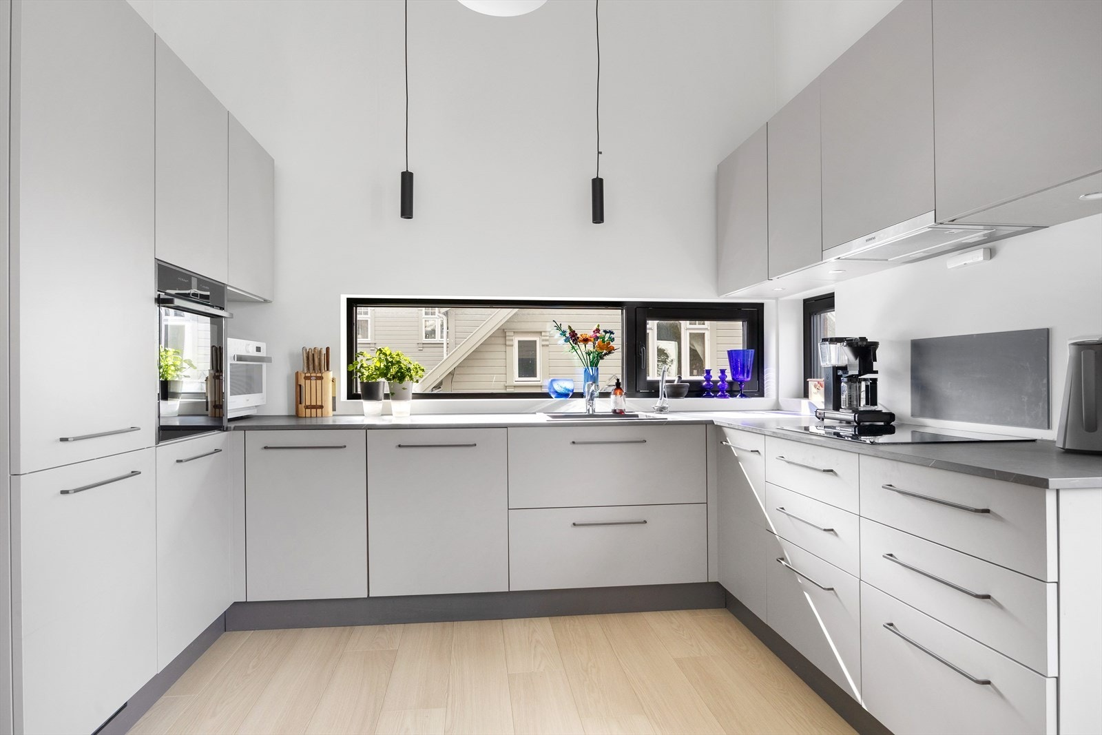 Det stilrene kjøkkenet kombinerer funksjonalitet og design. Med glatte fronter og laminert benkeplate utstyrt med nedfelt vask, får du her en arbeidsflate som er både elegant og lettstelt. Galleribilde