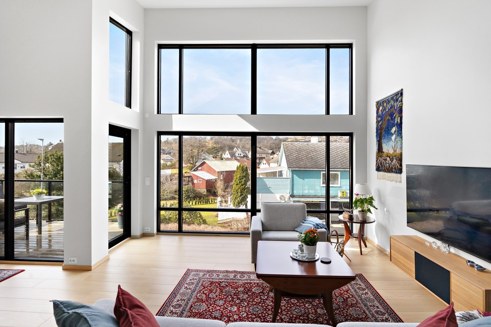 Et innbydende og sosialt allrom med åpen løsning mot kjøkkenet. Ekstra takhøyde og store vindusflater skaper en romslig og luftig atmosfære. Galleribilde