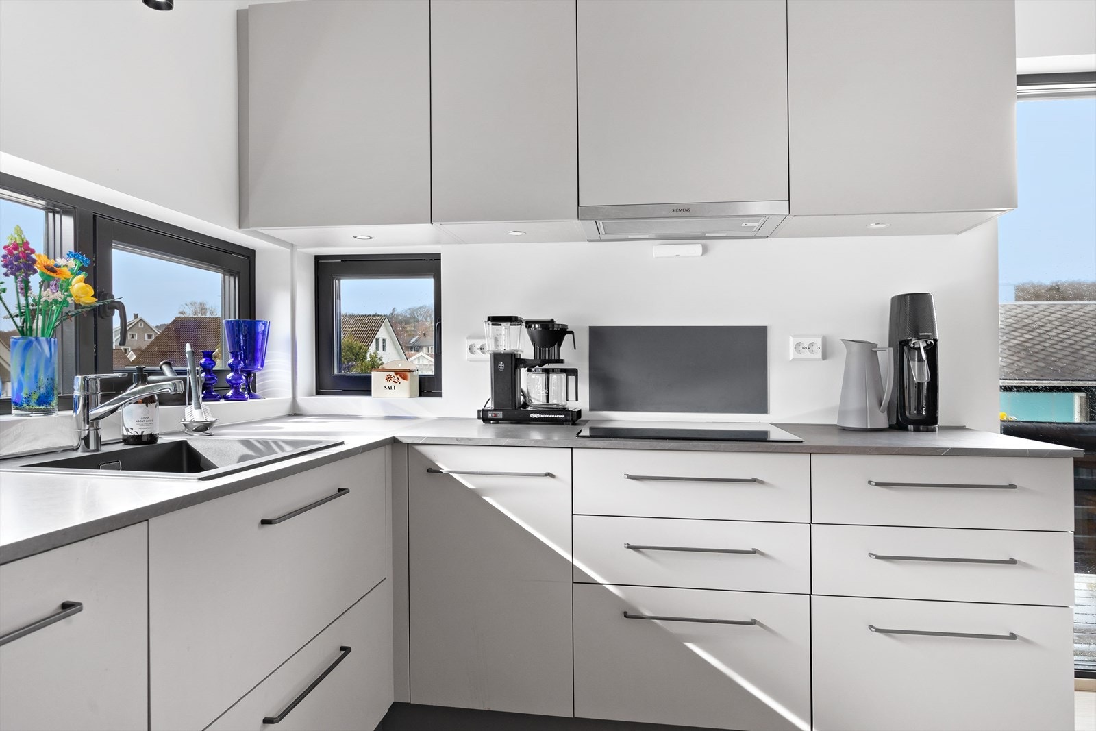 Det stilrene kjøkkenet kombinerer funksjonalitet og design. Med glatte fronter og laminert benkeplate utstyrt med nedfelt vask, får du her en arbeidsflate som er både elegant og lettstelt. Galleribilde
