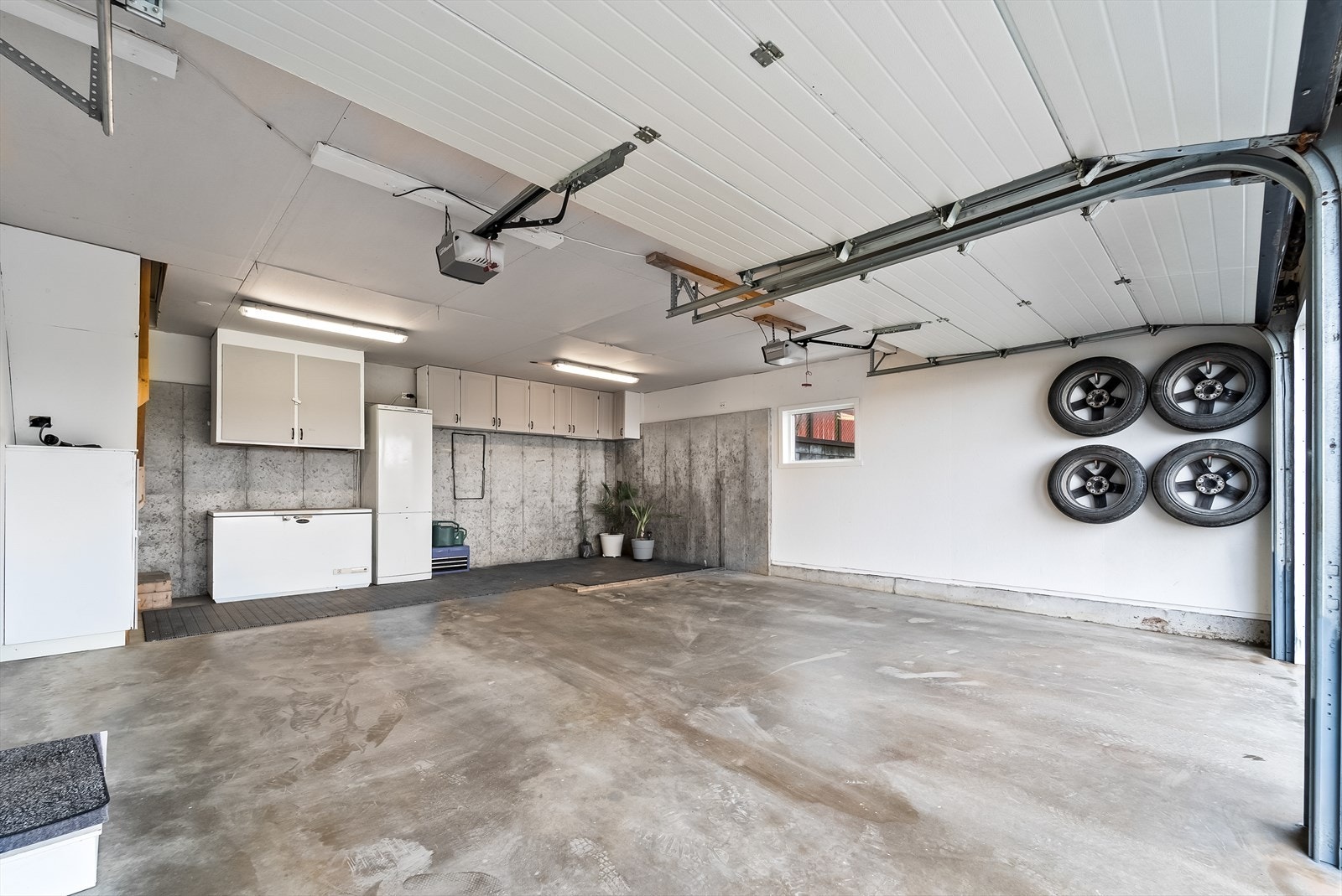 Romslig og ryddig garasje med oppbevaringsløsninger og plass til bil. Perfekt for bilentusiasten eller som verksted. Galleribilde