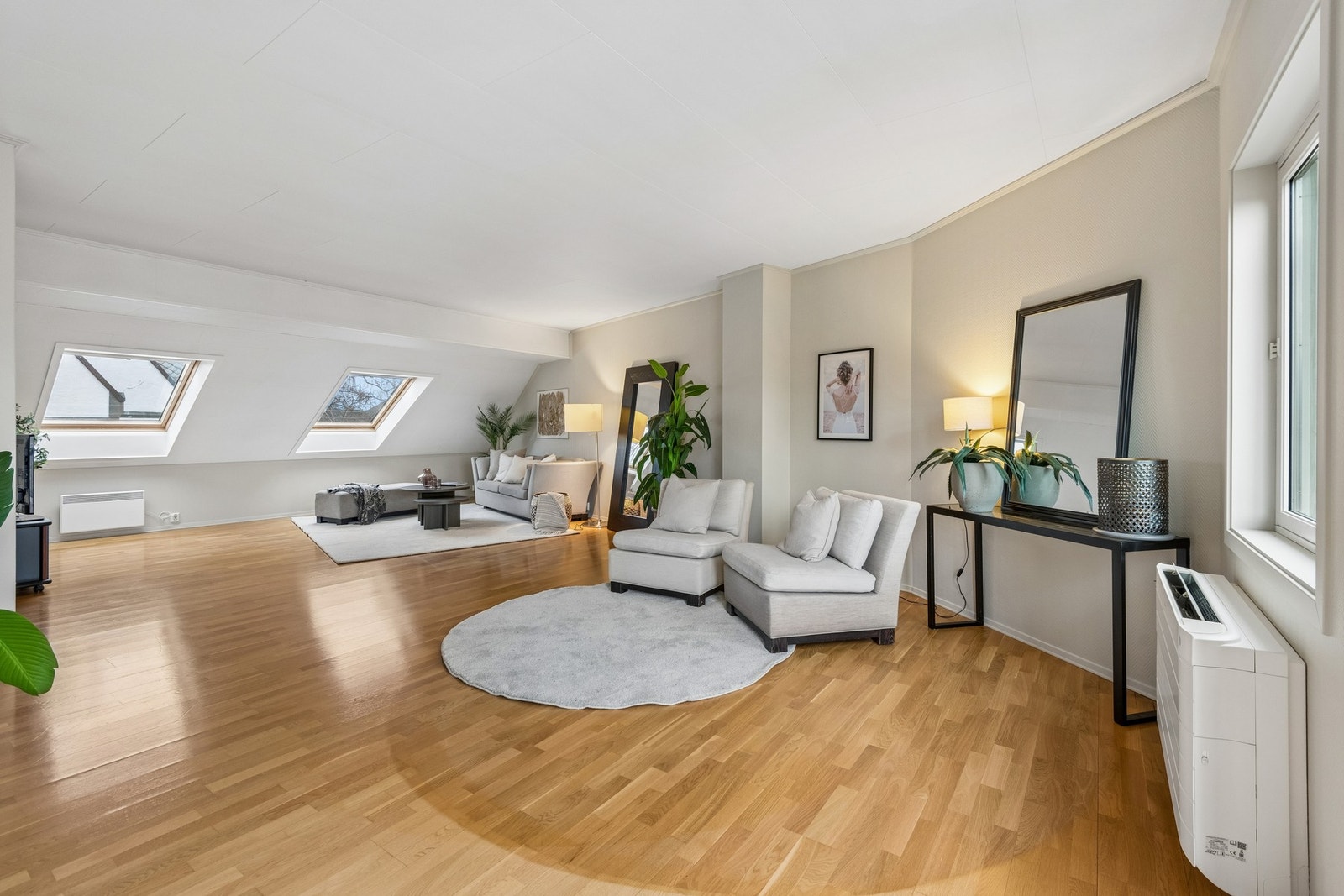 Åpen stue med store vindusflater som gir rikelig med naturlig lys og en luftig romfølelse. Galleribilde