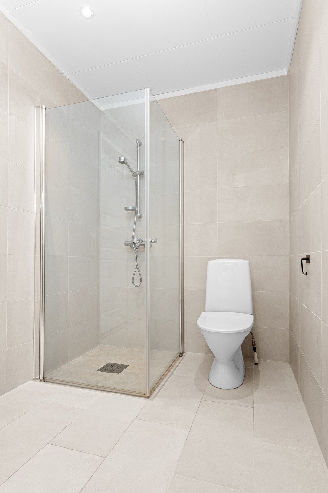 Baderomsinnredning med gode oppbevaringsløsninger. Videre er badet utstyrt med toalett og dusjhjørne. Opplegg for vaskemaskin og tørketrommel. Galleribilde