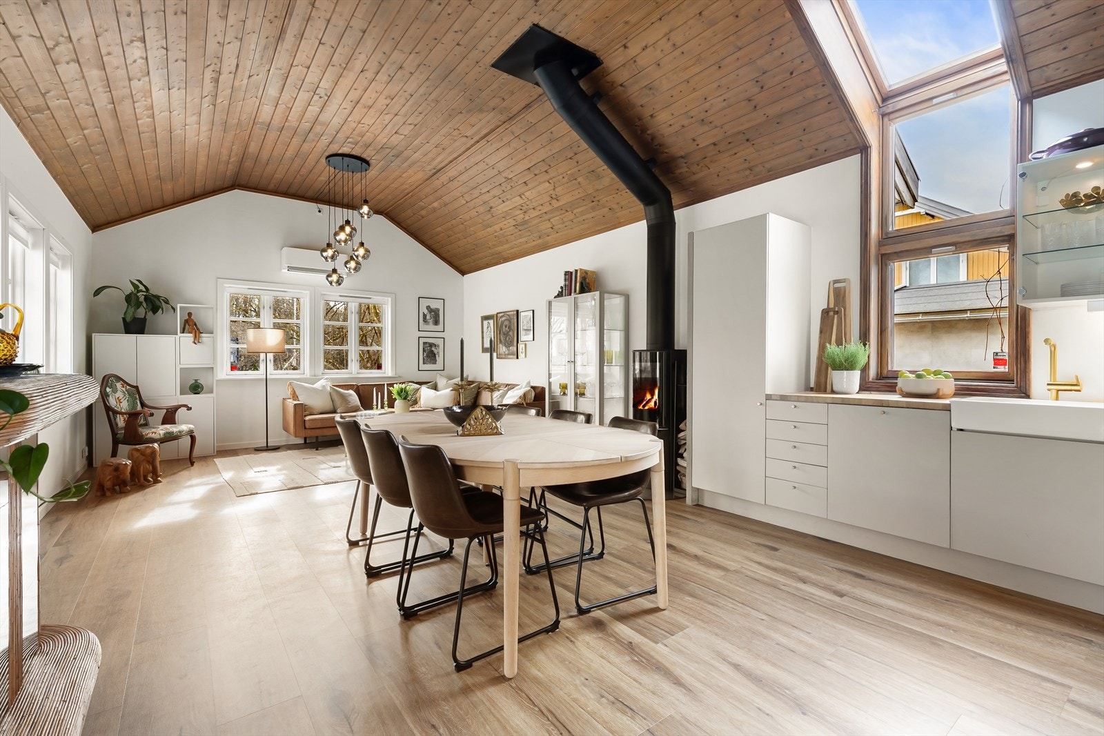 Romslig stue og kjøkken med rikelig av plass for spisestue med mange til bords og sofasalong Galleribilde