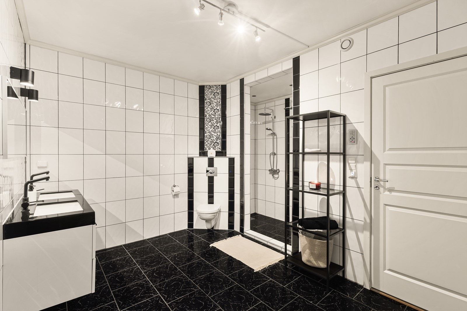 Badet er innredet med baderomsinnredning, speil og vegghengt toalett Galleribilde