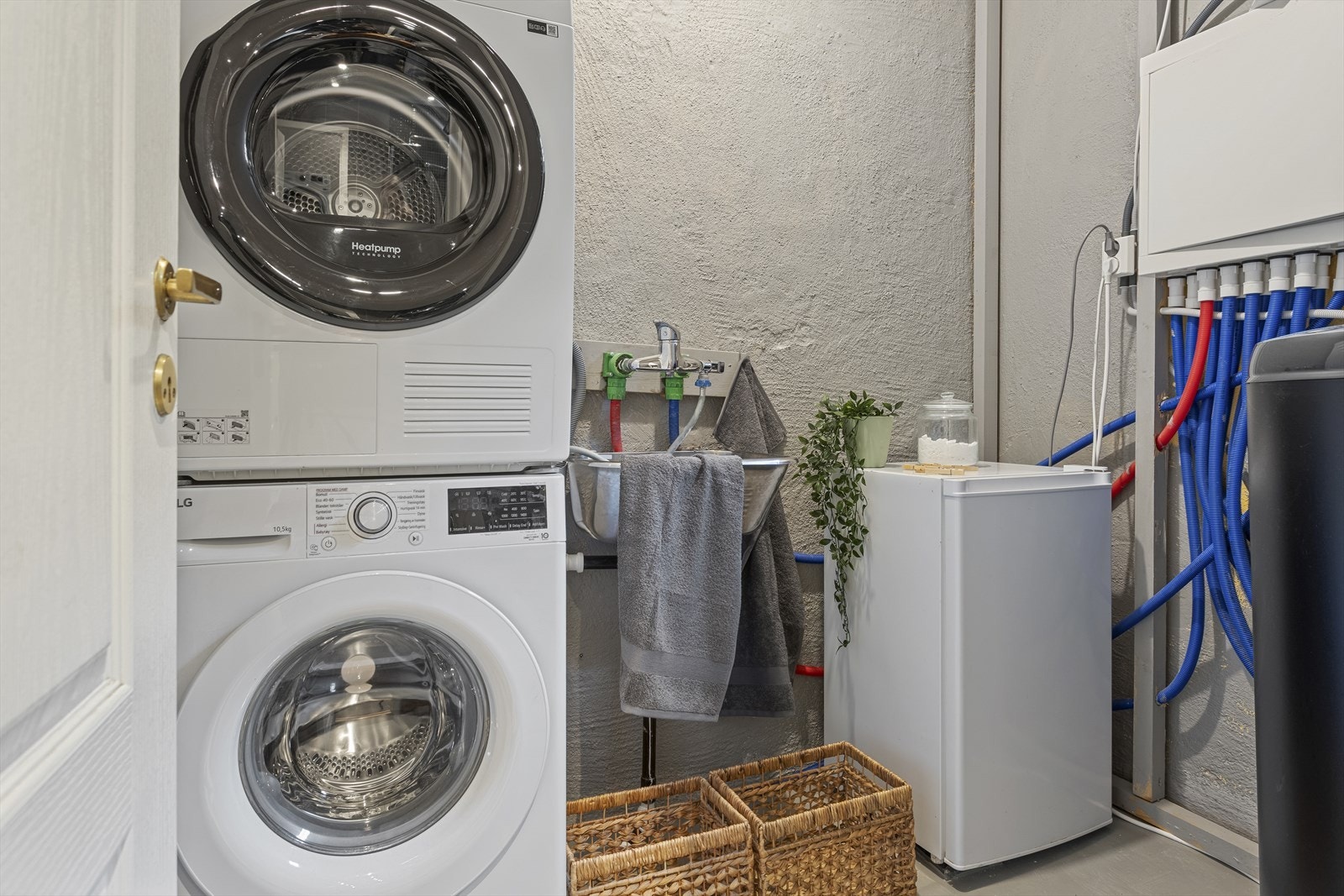 Praktisk vaskerom i boligens u. etg, som er innredet med opplegg for vaskemaskin, tørketrommel, rørskap/ fordelerskap, varmtvannstank og skyllekum i stål. Galleribilde