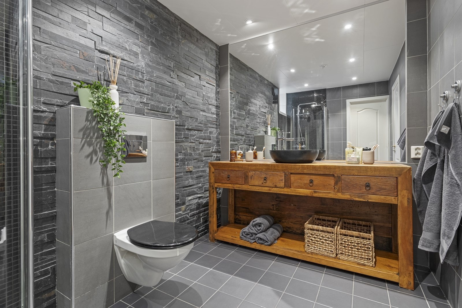 Romslig og pent flislagt bad, som ligger i boligens u. etg. Galleribilde