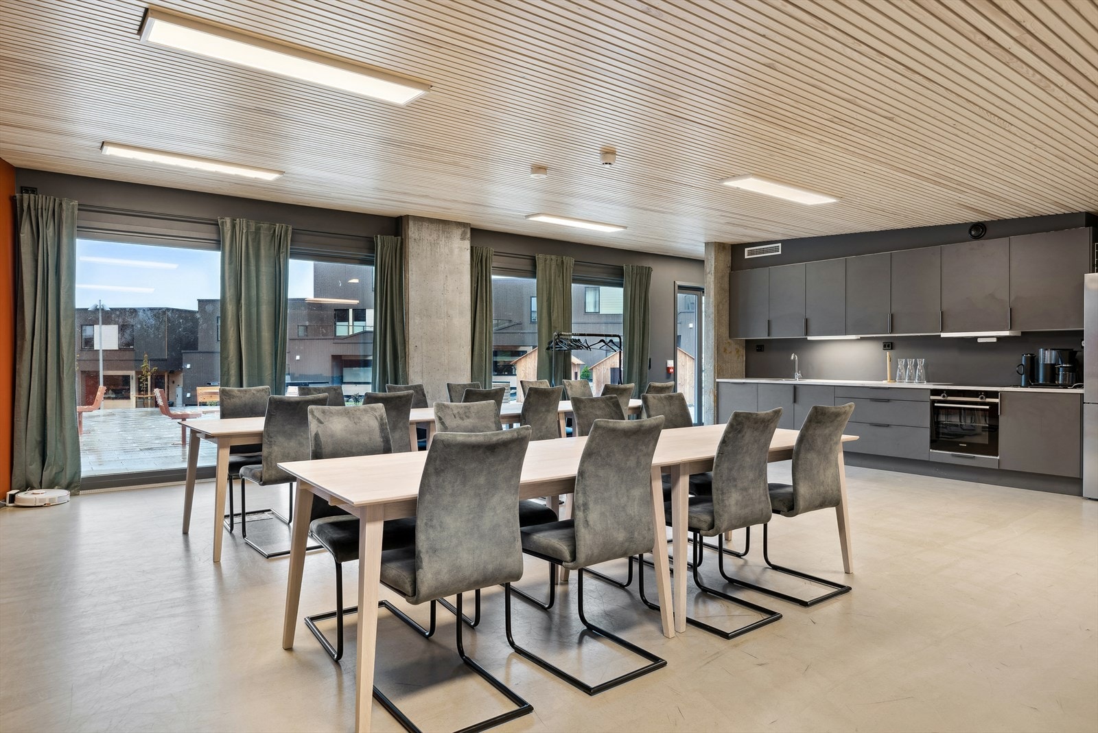 Felles selskapslokaler, utstyrt med bla. kjøkken, TV-skjerm og langbord. Galleribilde