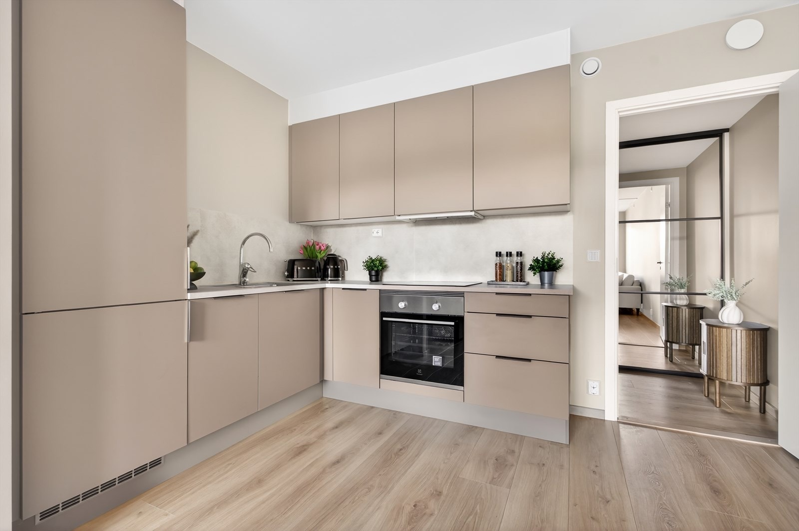 Innredningen er fra HTH, med stilrene, glatte fronter i grå/beige utførelse og lyse, laminerte benkeplater. Galleribilde