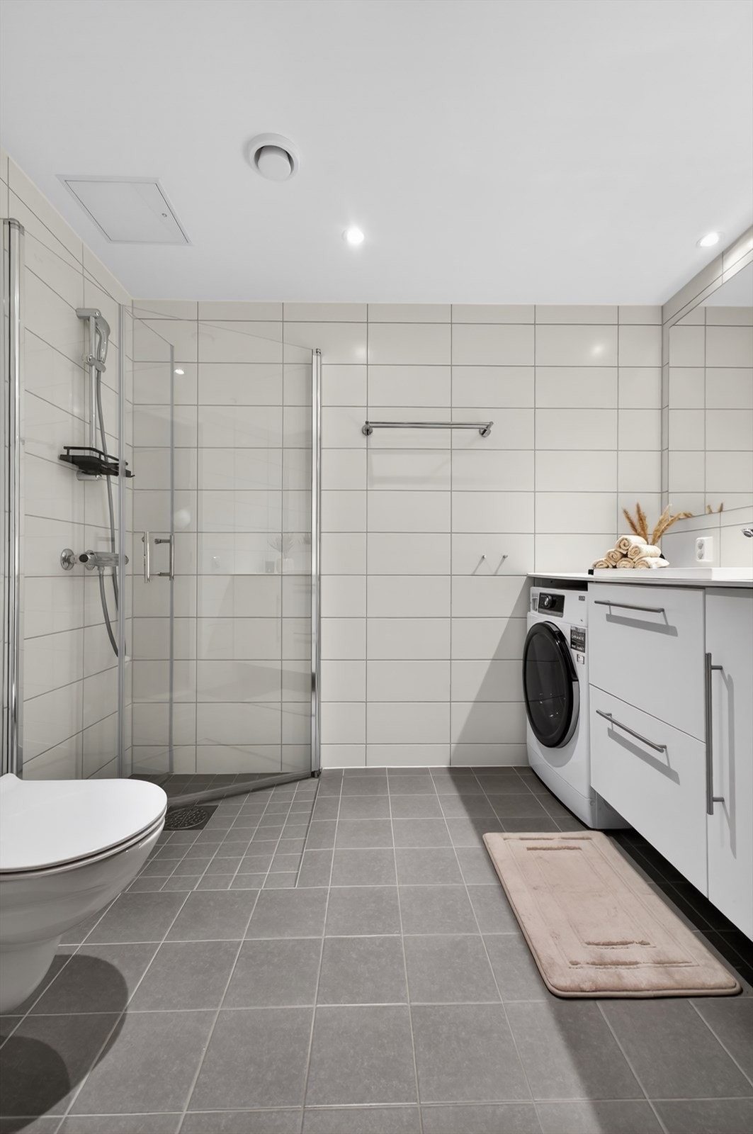 Dusjhjørne med nedfelt dusjsone, innfellbare glassdører, dusjbatteri og hånddusj. Galleribilde