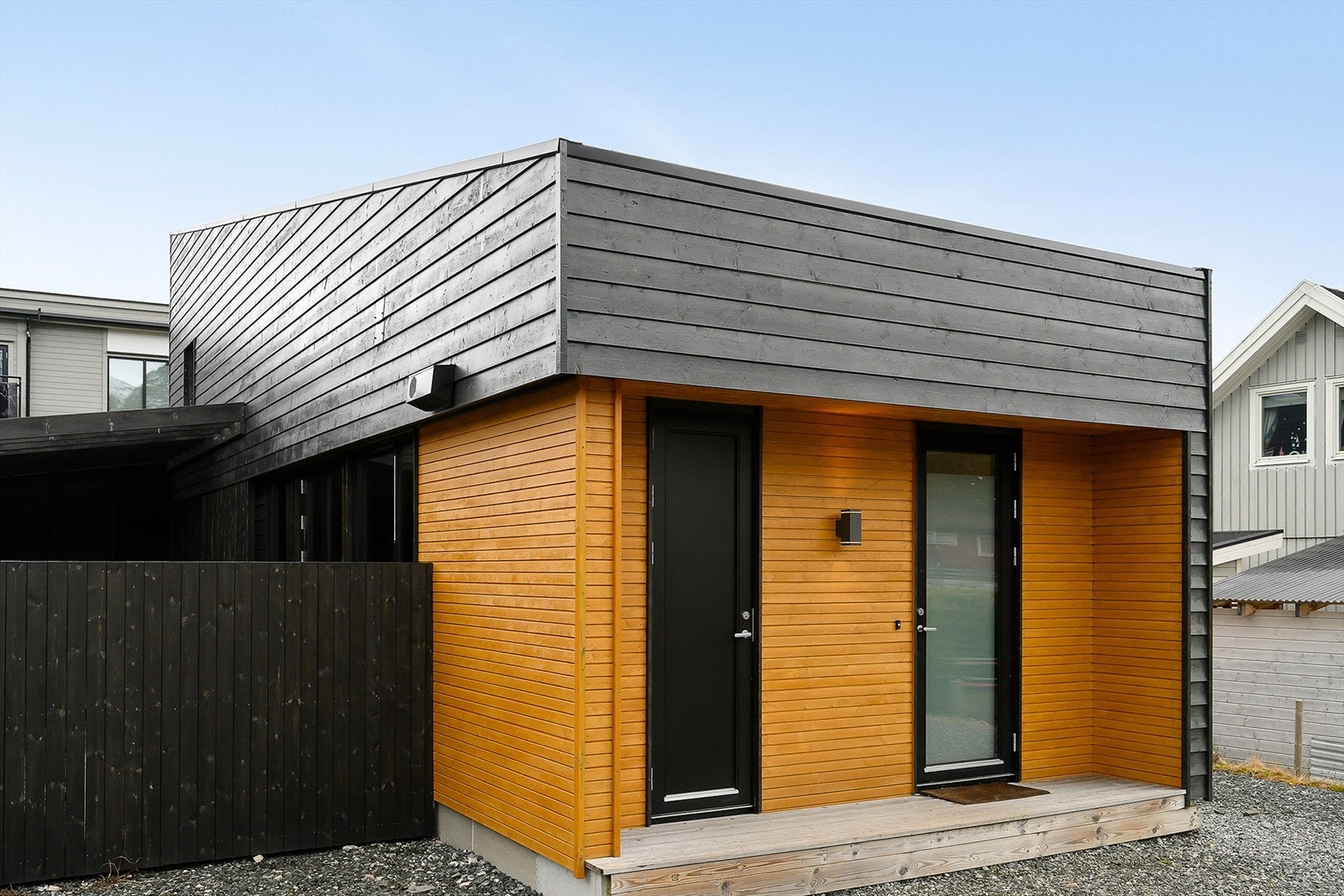 Gruslagt tun med takoverbygget inngangsparti med treplatning på omtrent 3 kvm. Her er det også tilkomst til bod. Galleribilde