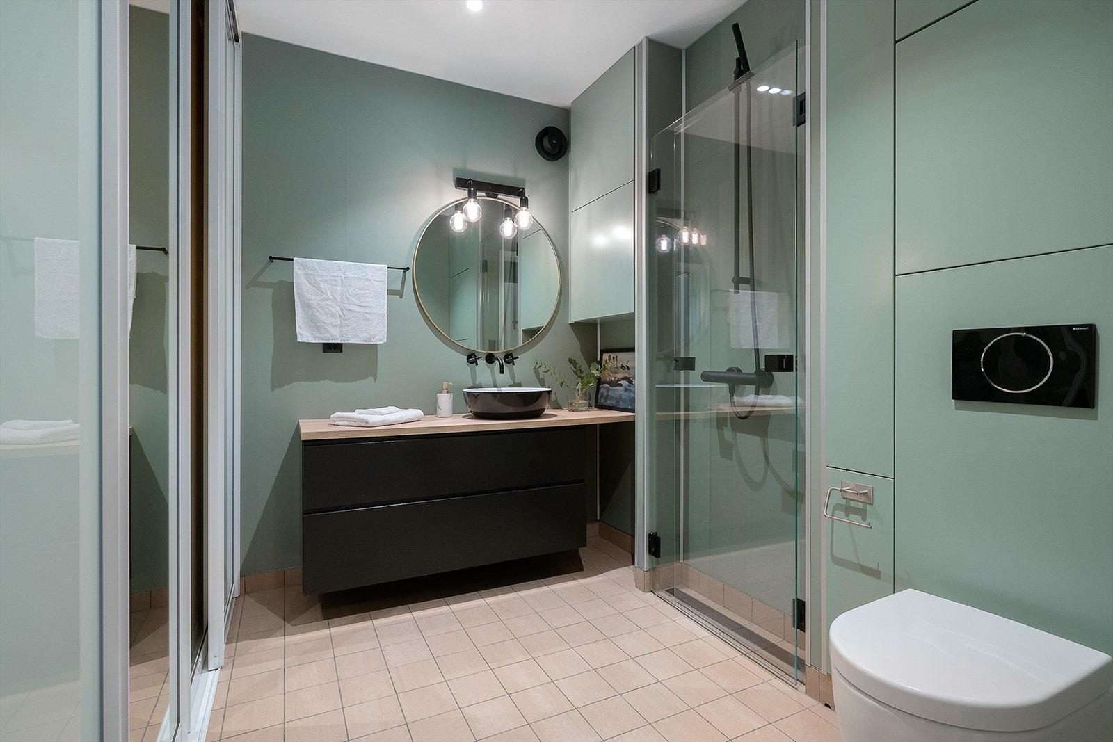 Badet er innredet med spesialtilpasset baderomsinnredning fra Jølster Bygg, bestående av veggskap i tilpasset veggfarge, skuffeseksjon med benkeplate og servantbolle. Galleribilde