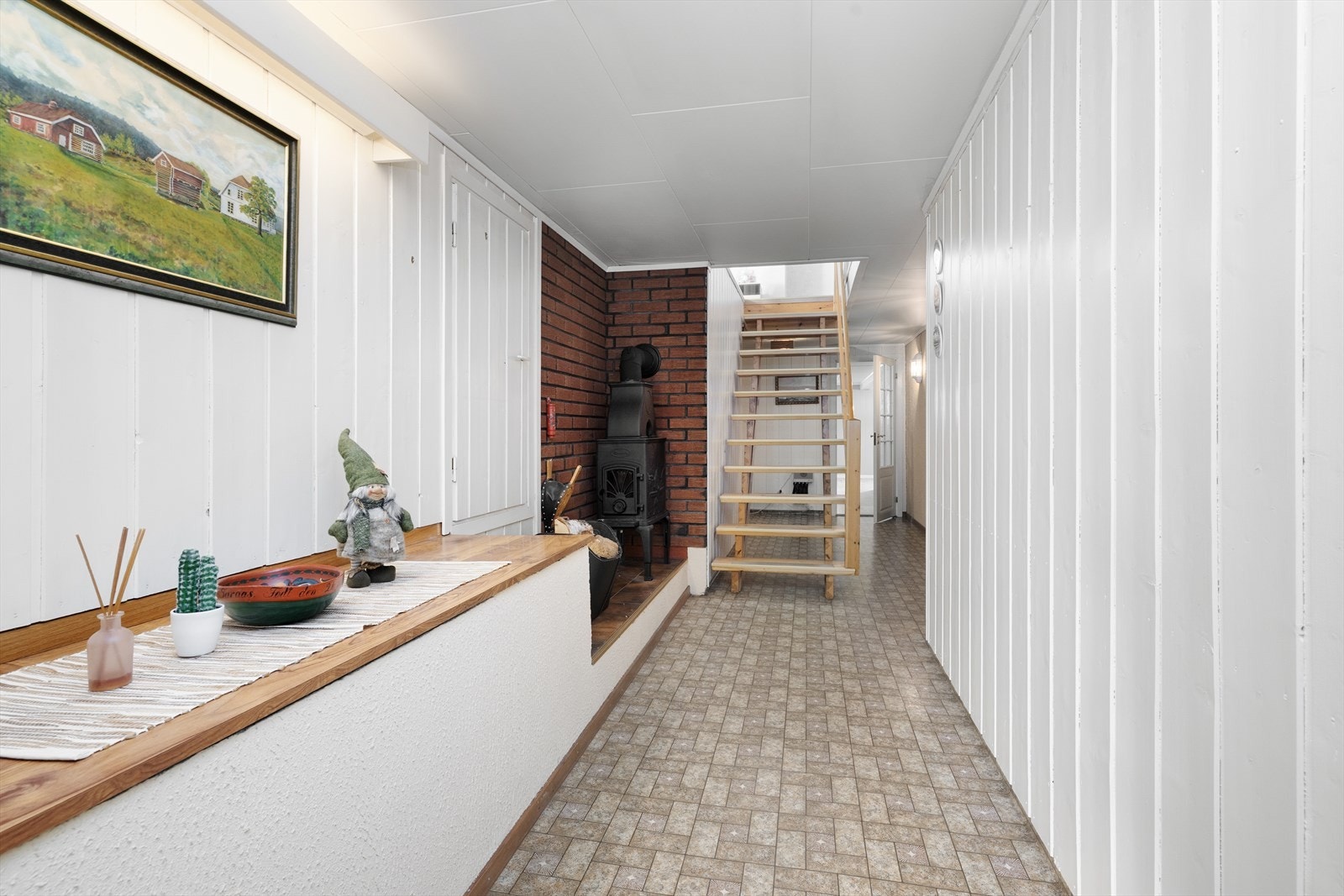 Trappegangen i hoveddel har vedovn og trapp opp til stue. Galleribilde