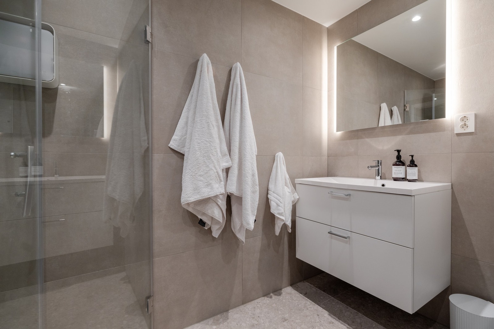 Servantinnredning med skuffer, kran fra Mora og tilhørende speil med belysning. Her er det også opplegg for vaskemaskin og tørketrommel Galleribilde