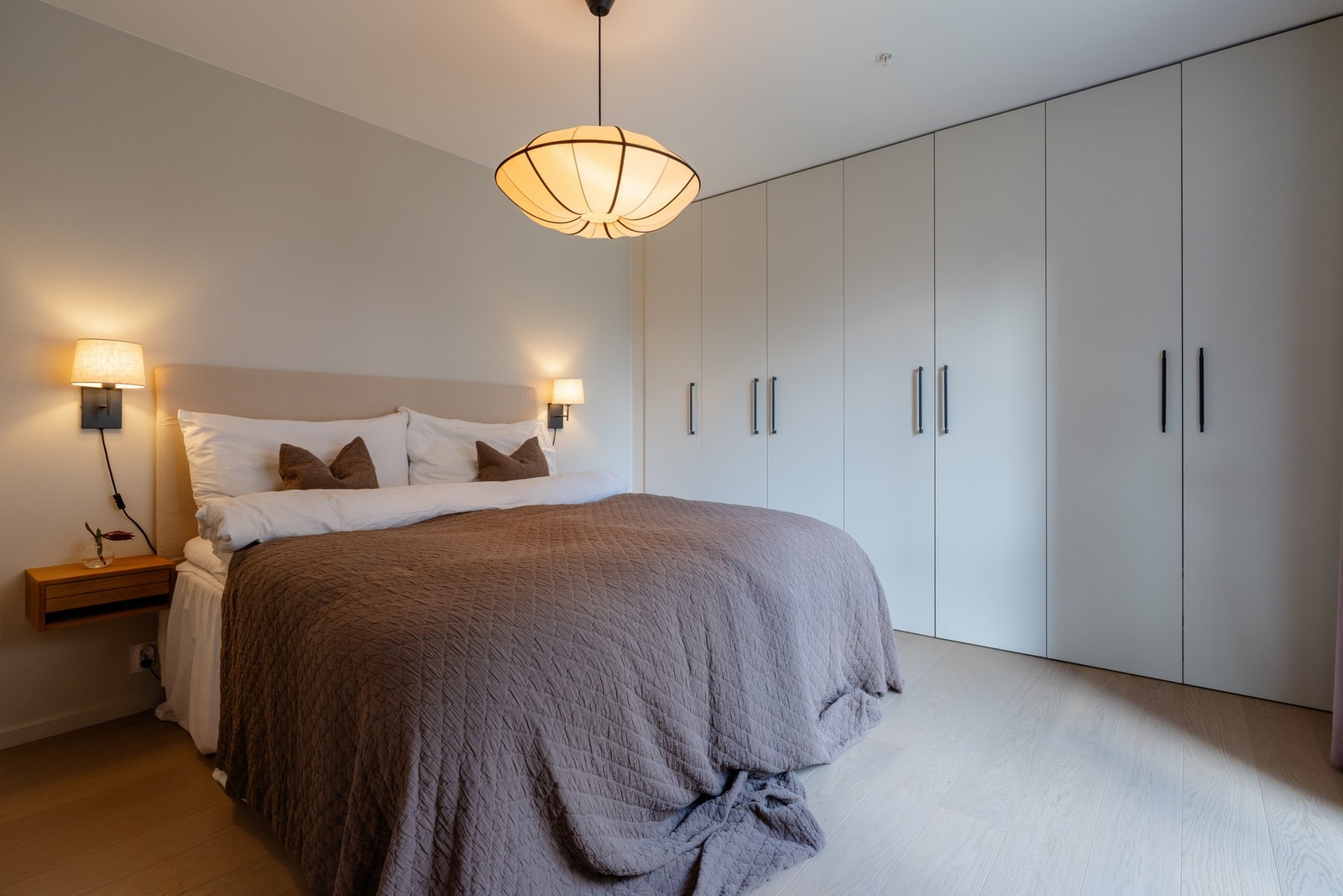 Romslig hovedsoverom med skaprekke fra vegg til vegg Galleribilde