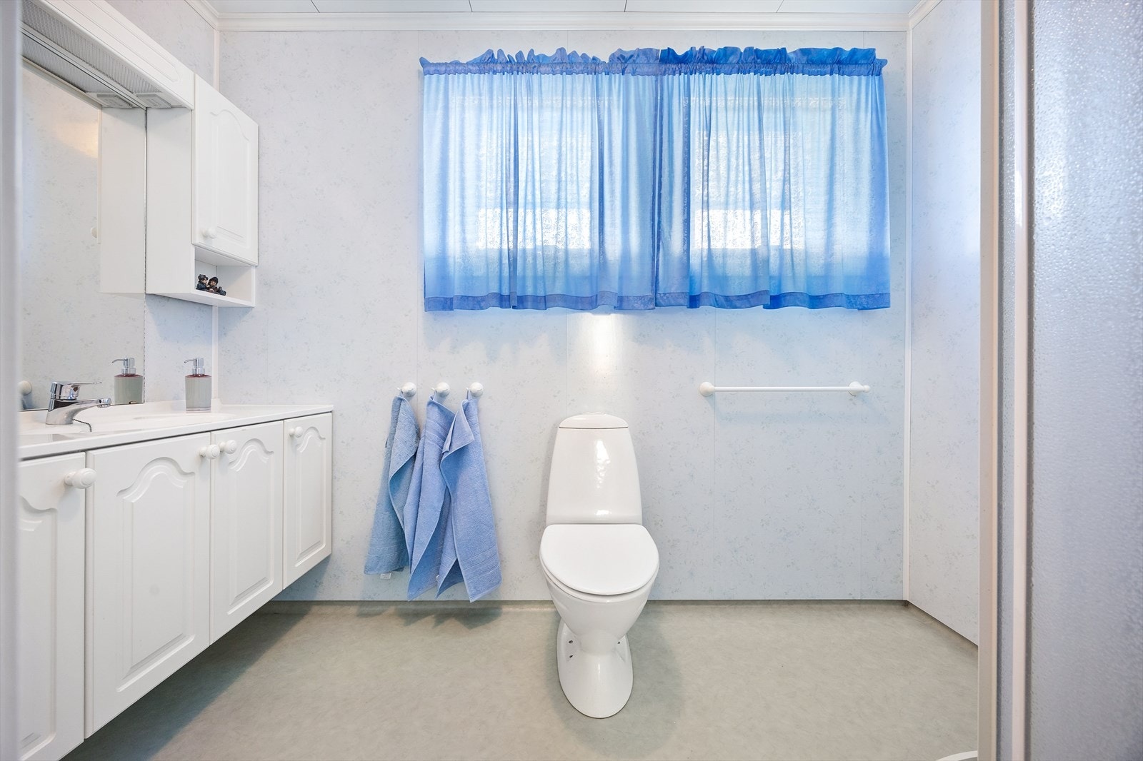 Badet er utstyrt med toalett, servantskap med profilerte fronter og dusj. Galleribilde