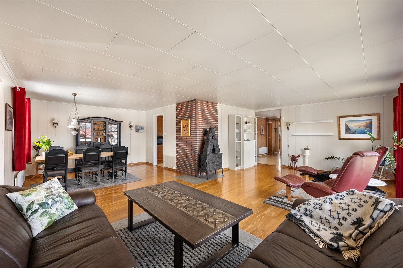 Gulvene i stuen har tre-stavs laminat, og veggene består av malt panel (Trysil-panel). Galleribilde