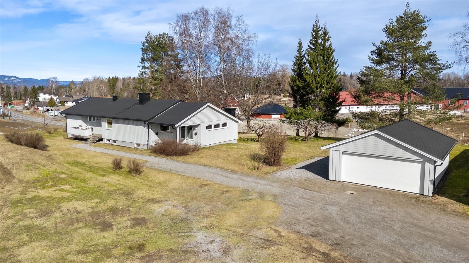 Eiendommen har en romslig og gruset gårdsplass, samt dobbelgarasje. Galleribilde