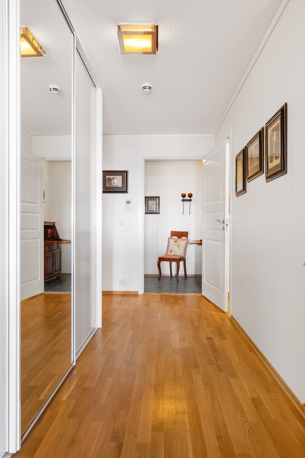 Lys og romslig gang med stor skyvedørsgarderobe og praktisk porttelefon som gjør det enkelt å både snakke med og slippe inn besøkende. Galleribilde