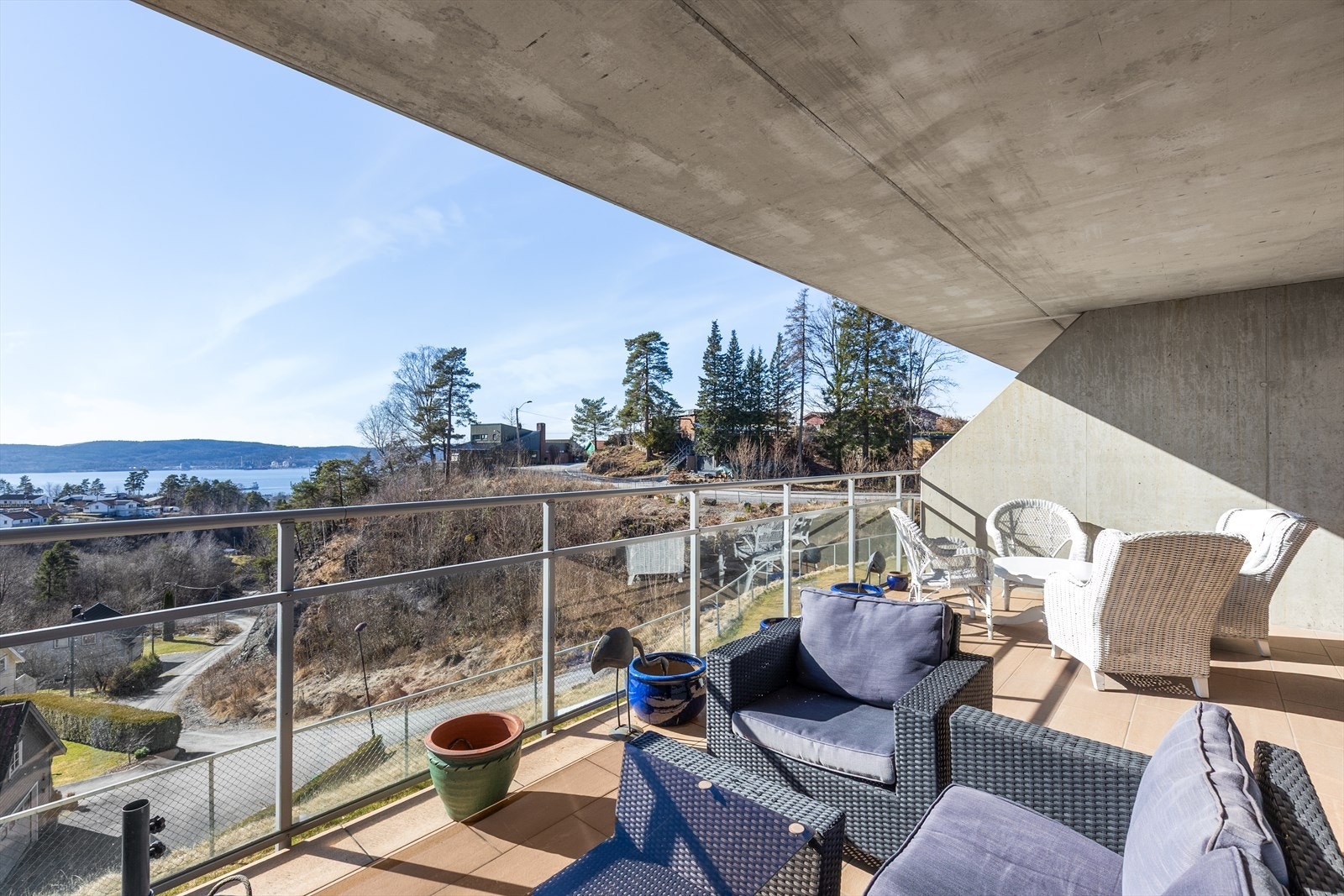 Terrassen ligger usjenert til, og er overbygget av terrasse ut fra leiligheten over. Flislagt dekke og pent glassrekkverk, som gjør at utsikten kan nytes til det fulle! Galleribilde