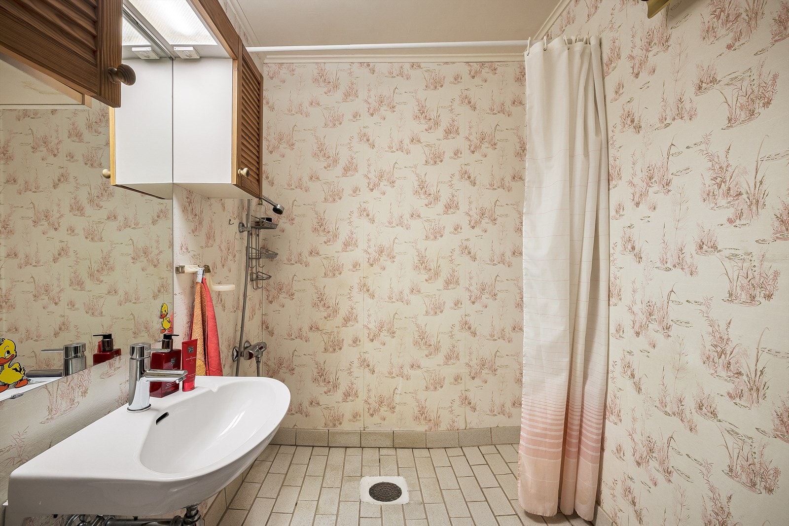 Badet er 4m2 og har Keramiske fliser på gulv, tapet på vegger og malt platekledning i himling. Galleribilde